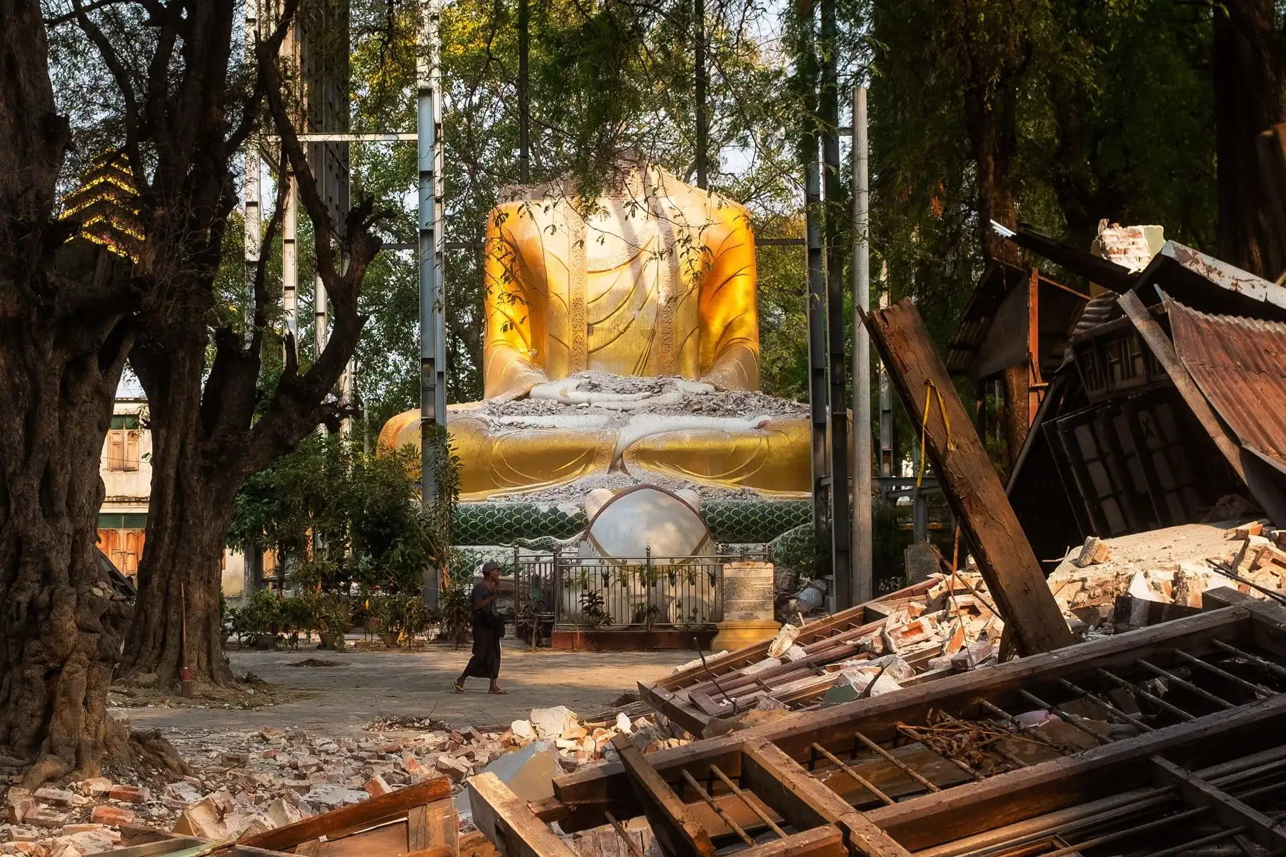 Una persona pasa junto a una escultura de Buda en un templo dañado tras un terremoto en Mandalay, Myanmar. Foto: EFE