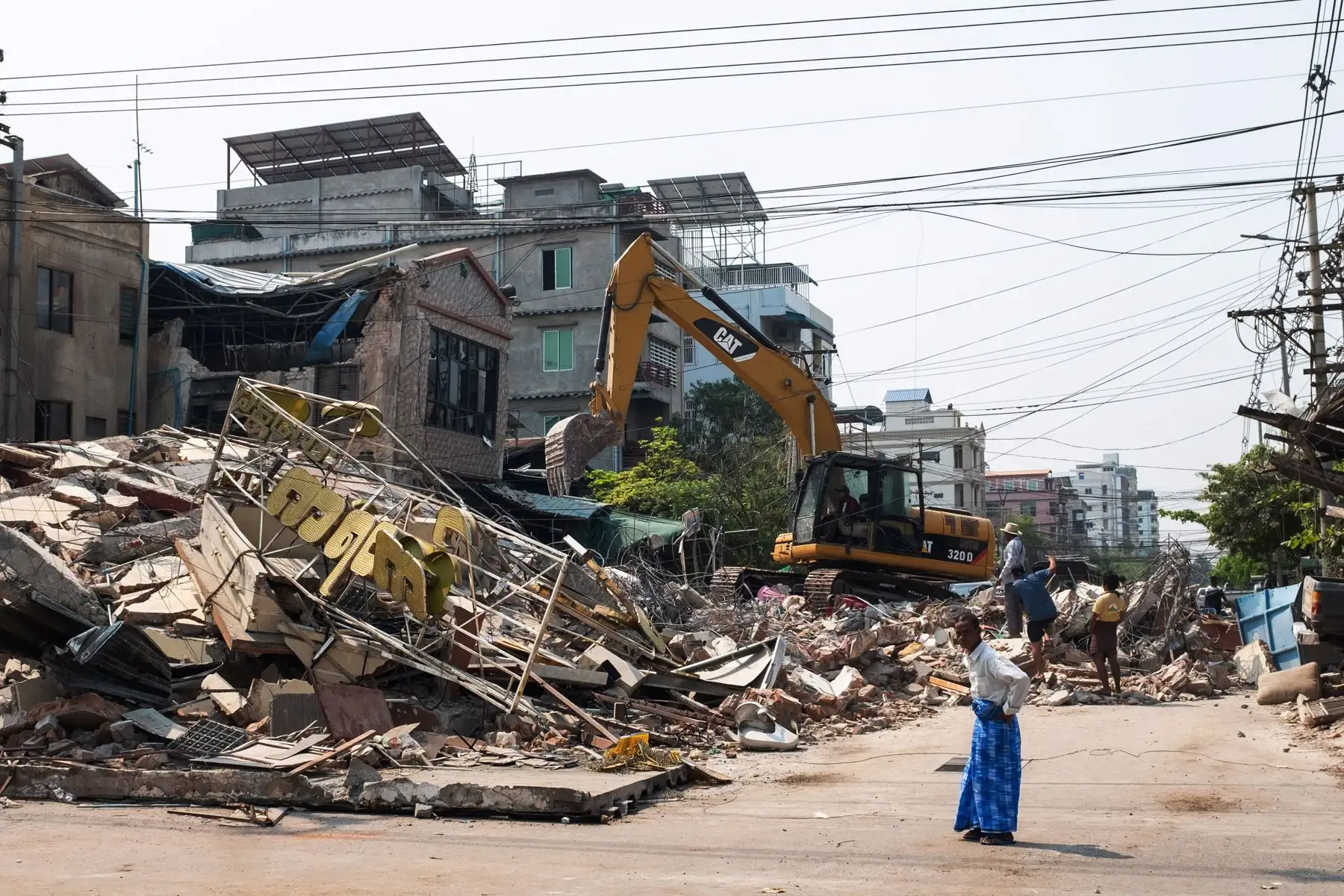Personas observan un edificio derrumbado tras un terremoto en Mandalay, Myanmar. Foto: EFE
