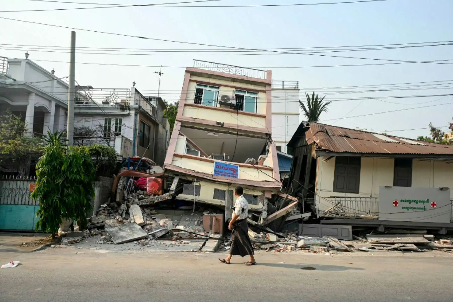 Un hombre pasa junto a un edificio derrumbado en Mandalay, pocos días después del mortífero terremoto de Myanmar. Tras pasar la noche tumbados sobre paneles de cartón bajo lonas de plástico instaladas a toda prisa, cientos de residentes de Mandalay se levantaron para otro día de recuperación tras el terremoto. Foto: AFP