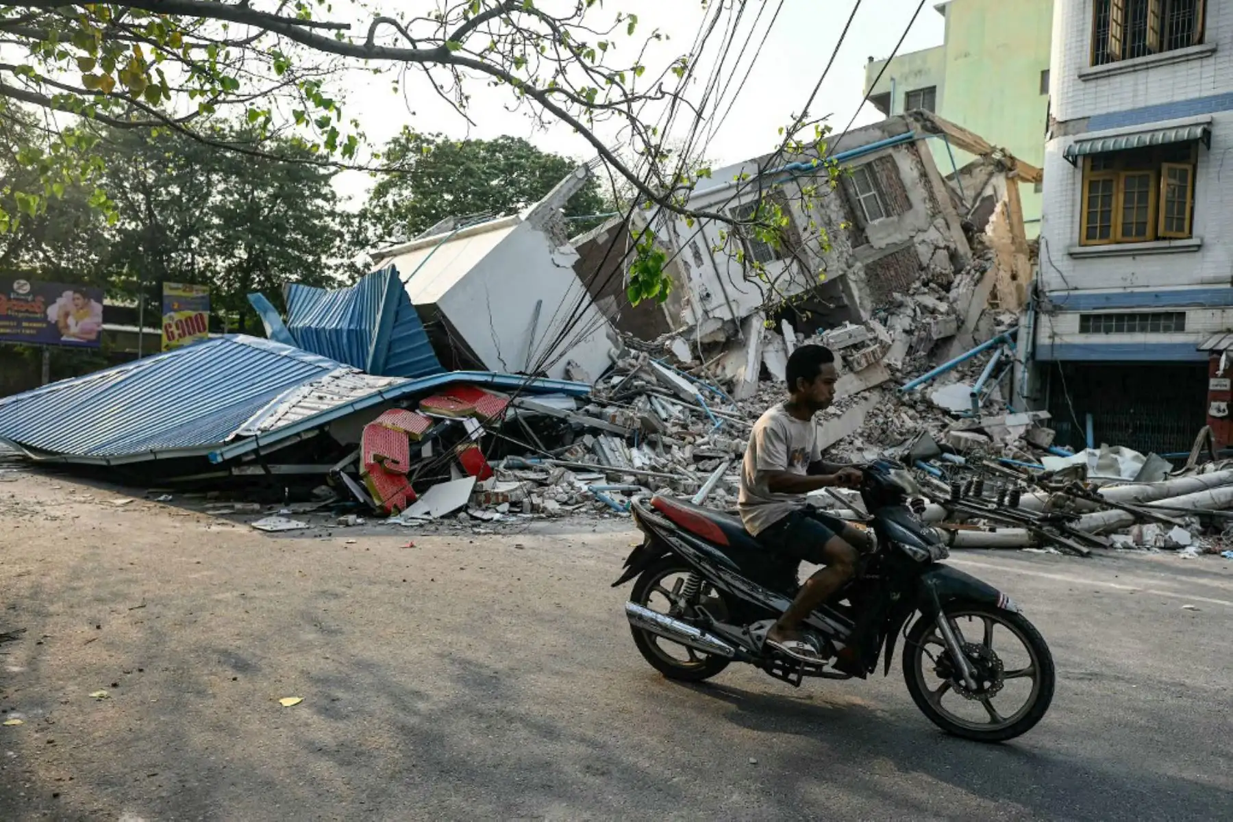 Un hombre pasa junto a un edificio derrumbado en Mandalay, pocos días después del mortífero terremoto de Myanmar. Tras pasar la noche tumbados sobre paneles de cartón bajo lonas de plástico instaladas a toda prisa, cientos de residentes de Mandalay se levantaron para otro día de recuperación tras el terremoto. Foto: AFP