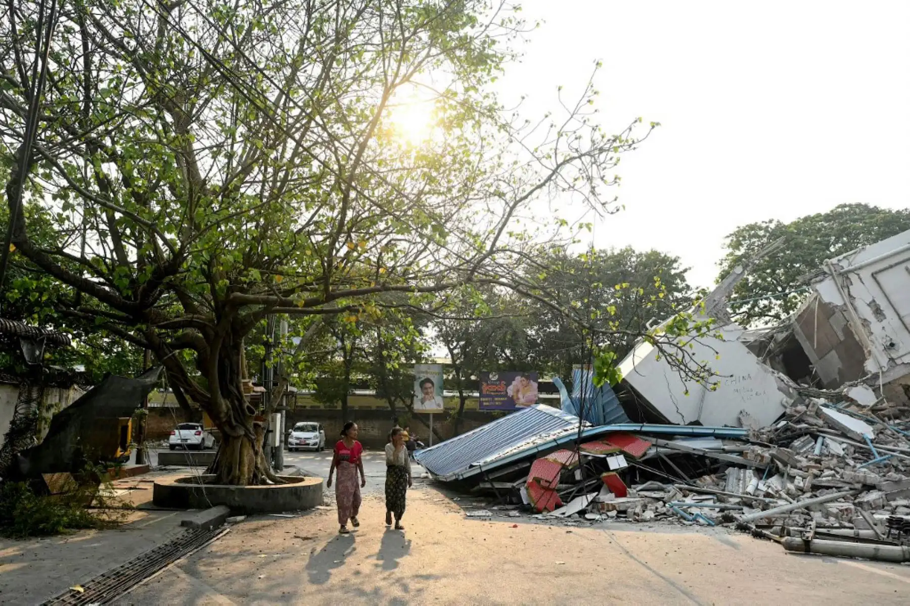 Personas pasan junto a un edificio derrumbado en Mandalay, pocos días después del mortífero terremoto de Myanmar. Tras pasar la noche tumbados sobre paneles de cartón bajo lonas de plástico instaladas a toda prisa, cientos de residentes de Mandalay se levantaron para otro día de recuperación tras el terremoto. Foto: AFP