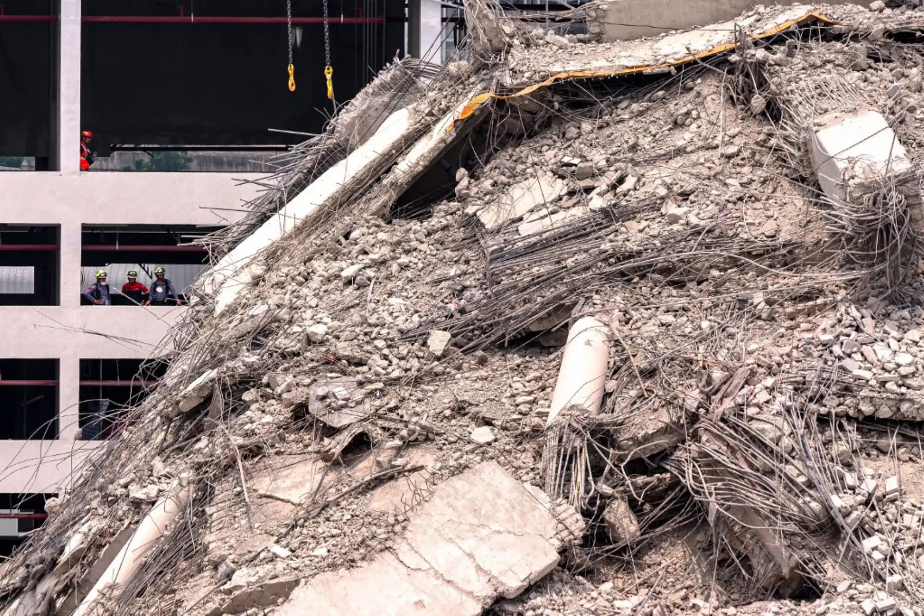 Rescatistas sobre los escombros en el lugar del derrumbe de un edificio en construcción en Bangkok. Foto: AFP