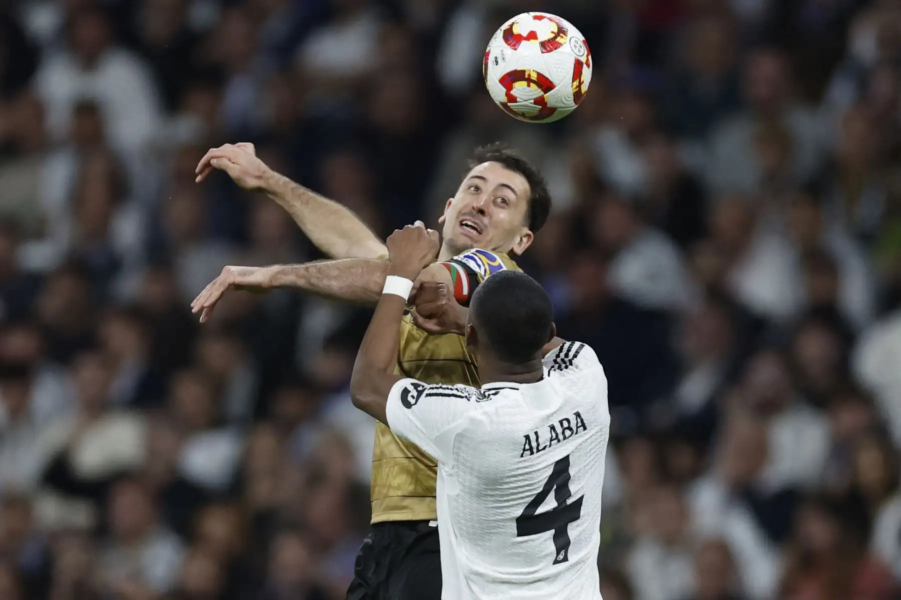 El centrocampista español del Real Sociedad, Mikel Oiarzabal, lucha por el balón con el defensor austríaco del Real Madrid, David Alaba, durante el partido de vuelta de la semifinal de la Copa del Rey entre el Real Madrid y el Real Sociedad en el estadio Santiago Bernabéu de Madrid el 1 de abril de 2025. Foto: AFP