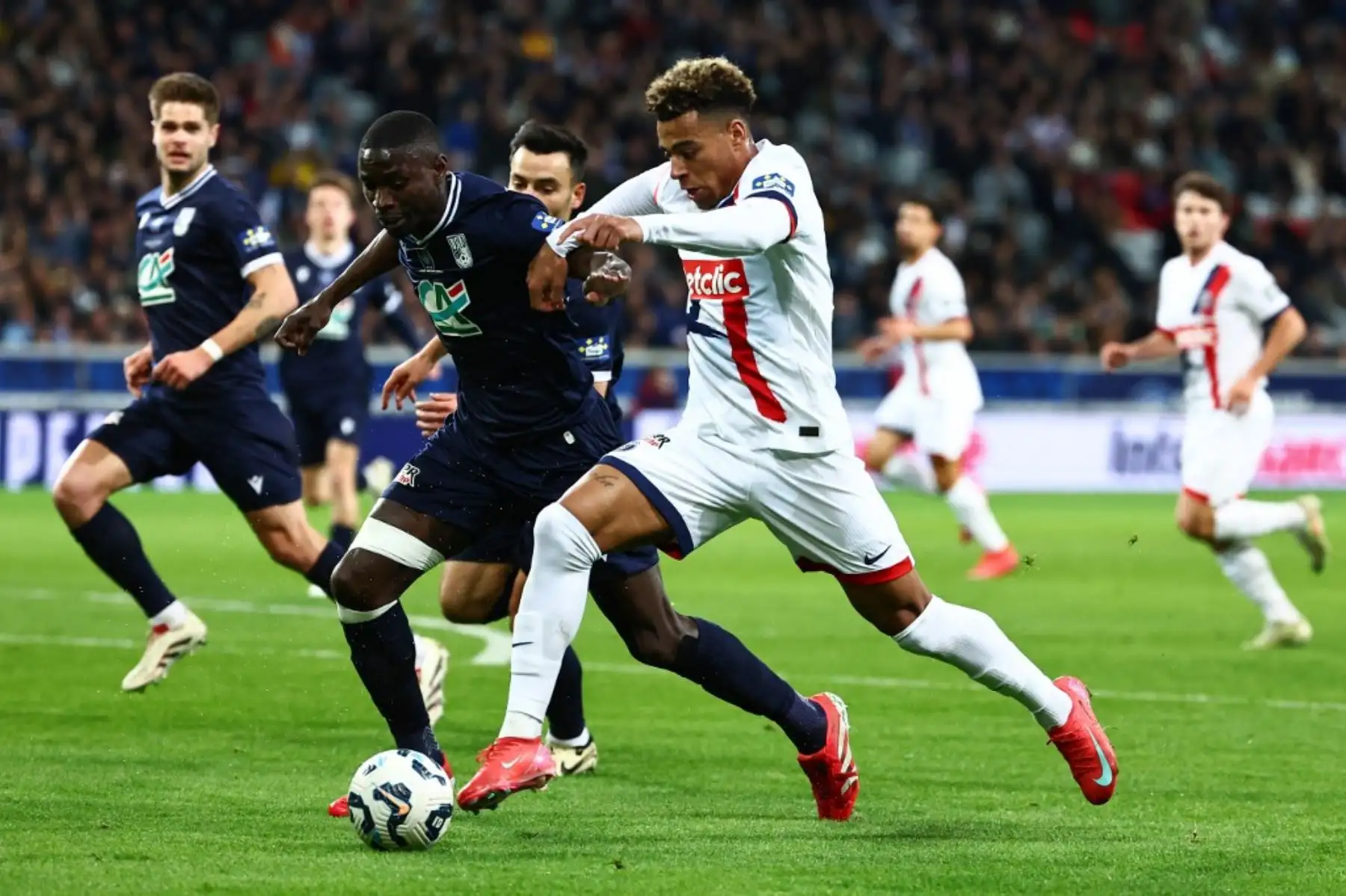 El delantero francés del Paris Saint-Germain, Desire Doue, lucha por el balón con el defensor francoguineano Opa Sangante del Dunkerque durante el partido de semifinales de la Copa de Francia entre el USL Dunkerque y el Paris Saint-Germain (PSG) en el estadio Pierre-Mauroy en Villeneuve-d