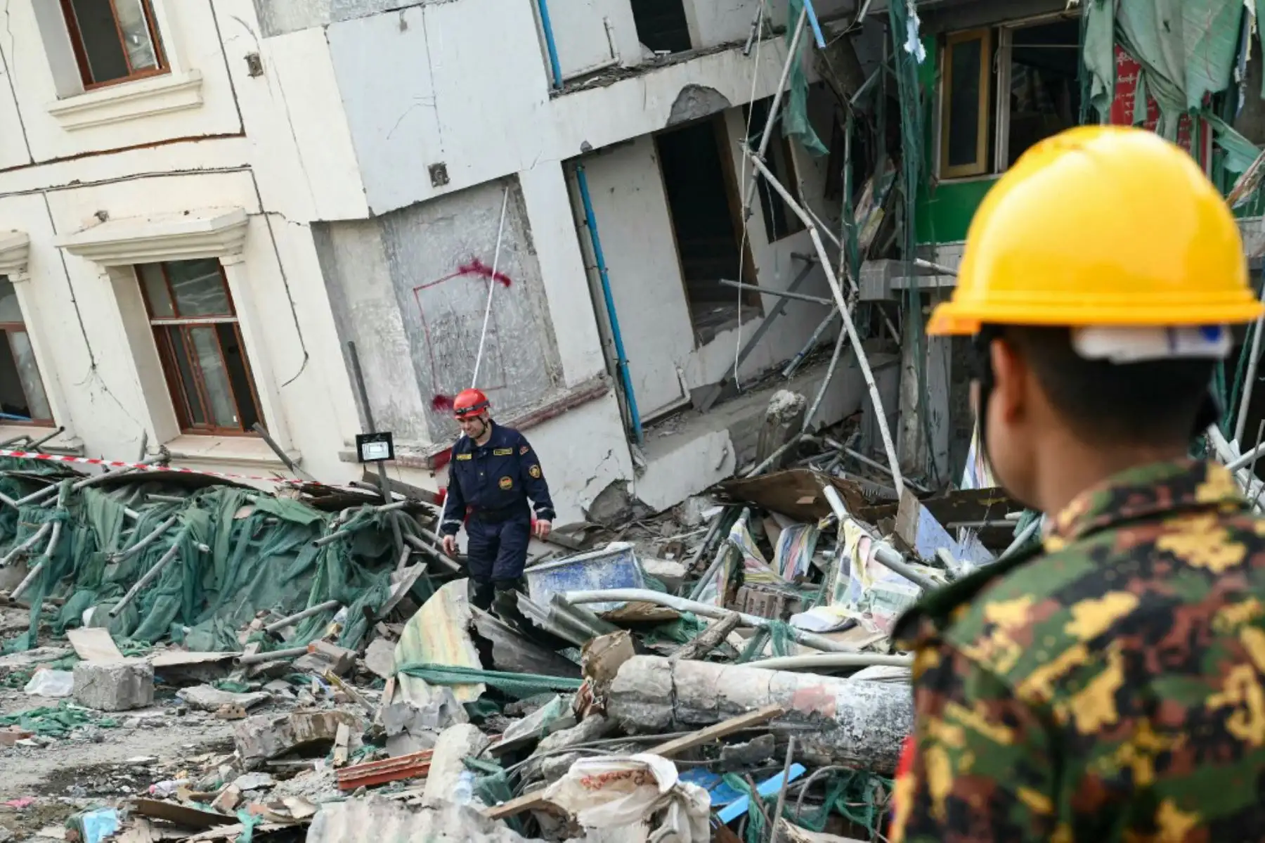 Un miembro de un equipo de rescate bielorruso camina entre los escombros junto a un edificio derrumbado en Mandalay el 2 de abril de 2025, cinco días después de que un gran terremoto azotara el centro de Myanmar. Foto: AFP