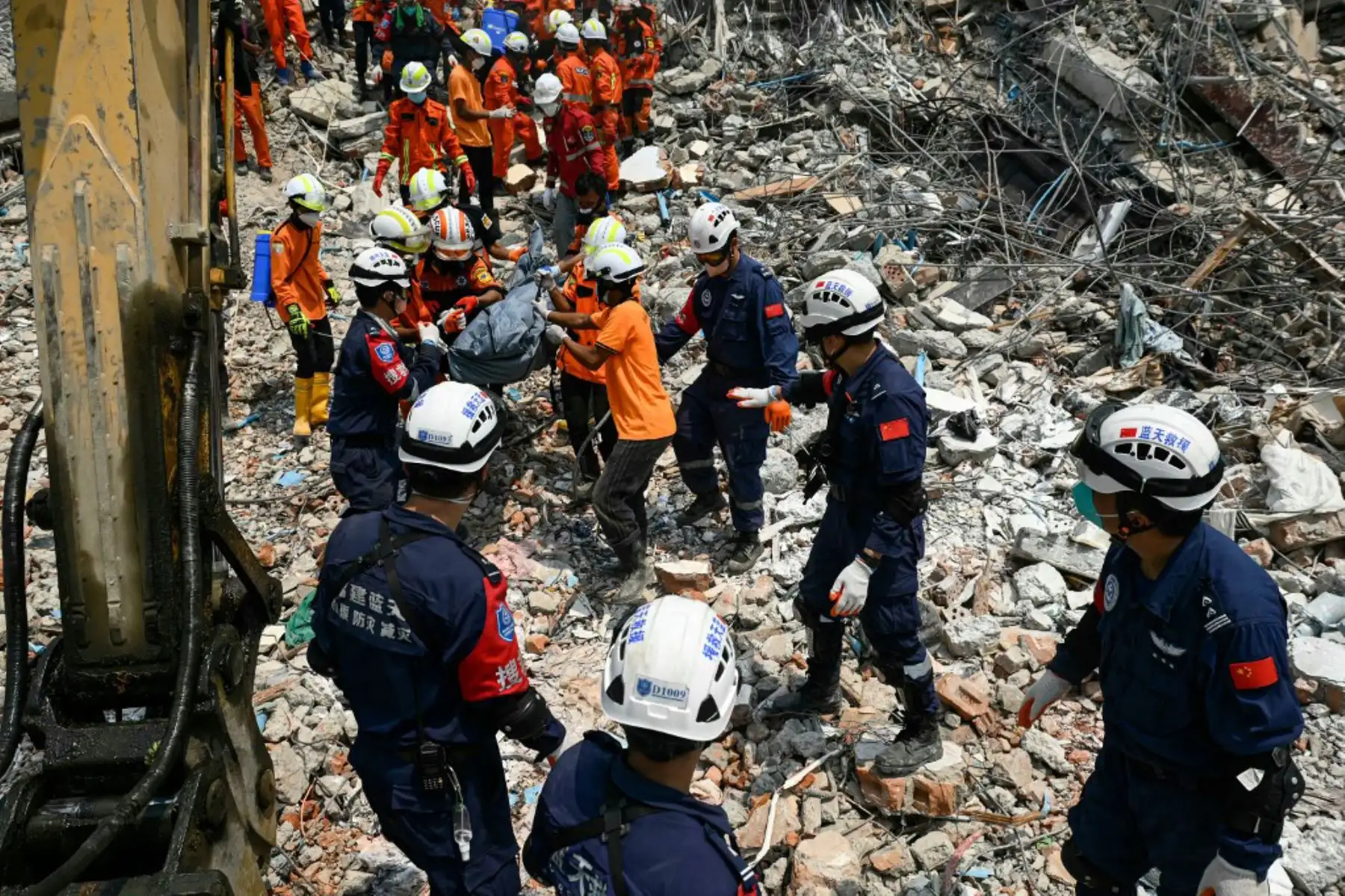 Rescatistas chinos y de Yanmar cargan el cuerpo de una víctima atrapada bajo los escombros del edificio derrumbado "Sky Villa Condominium development" en Mandalay el 2 de abril de 2025, cinco días después de que un fuerte terremoto azotara el centro de Myanmar. Foto: AFP