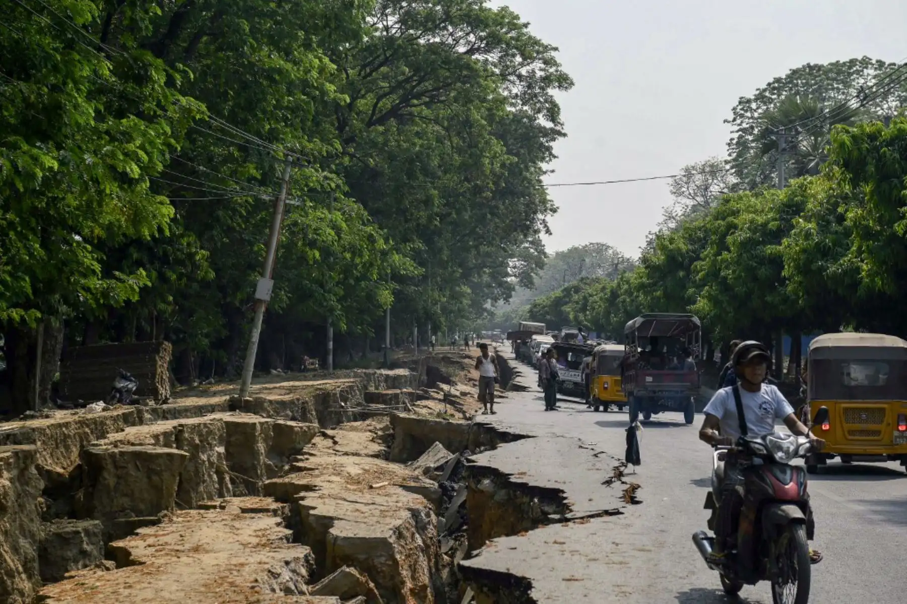 Los conductores pasan junto a una gran grieta en el suelo a lo largo de la carretera Myo Patt, que une Mandalay con el municipio de Sagaing, en las afueras de Mandalay, el 2 de abril de 2025, cinco días después de que un gran terremoto azotara el centro de Myanmar. Foto: AFP