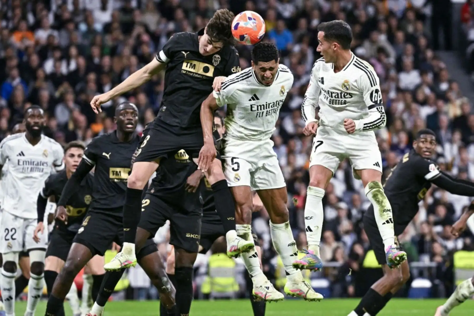 El centrocampista inglés del Real Madrid, Jude Bellingham, y el centrocampista español del Valencia, Javi Guerra, se lanzan a la portería durante el partido de fútbol de La Liga de España entre el Real Madrid CF y el Valencia CF en el estadio Santiago Bernabéu de Madrid el 5 de abril de 2025. Foto: AFP