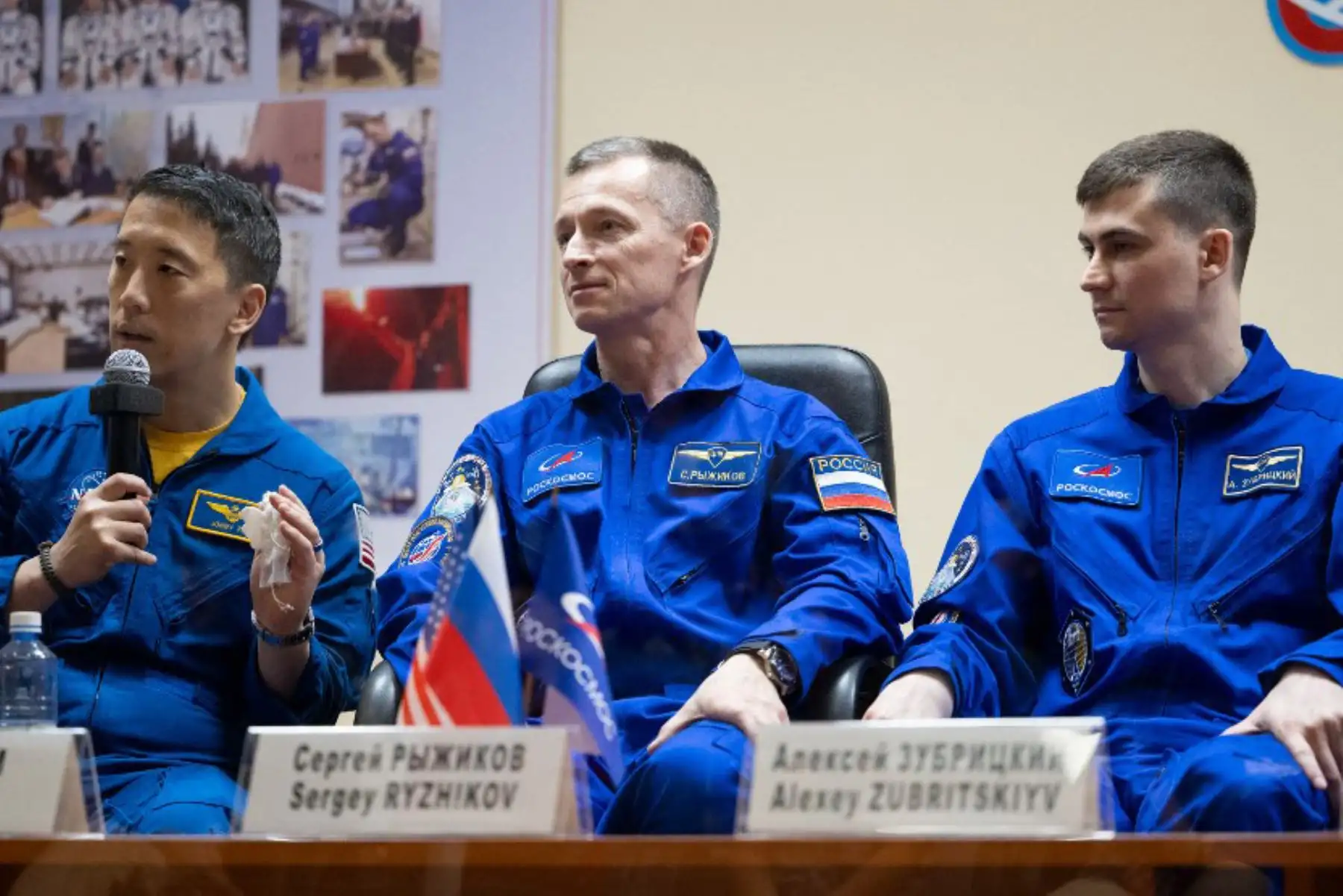 Los cosmonautas de Roscosmos, Sergey Ryzhikov y Alexey Zubritskiy, y el astronauta estadounidense de la NASA, Jonathan Yong "Jonny" Kim, durante una conferencia de prensa tras un cristal durante su cuarentena en el Hotel Cosmonaut en Baikomur, el 7 de abril del 2025,  en vísperas de su lanzamiento a bordo de la nave espacial Soyuz MS-27. Foto: AFP / NASA / Joel Kowsky