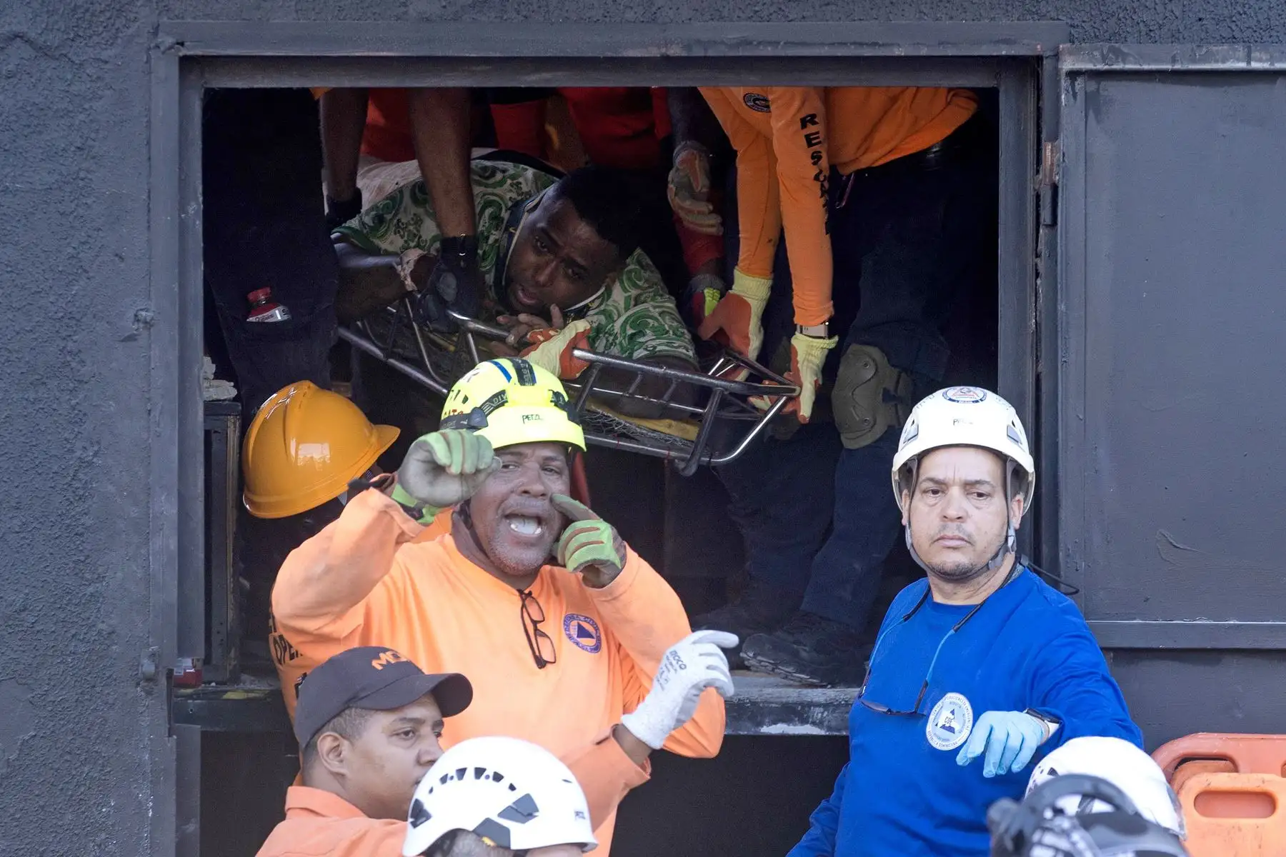 Integrantes del cuerpo de bomberos y de rescate evacuan a un herido este martes, en la discoteca Jet Set en Santo Domingo (República Dominicana). Foto: AFP