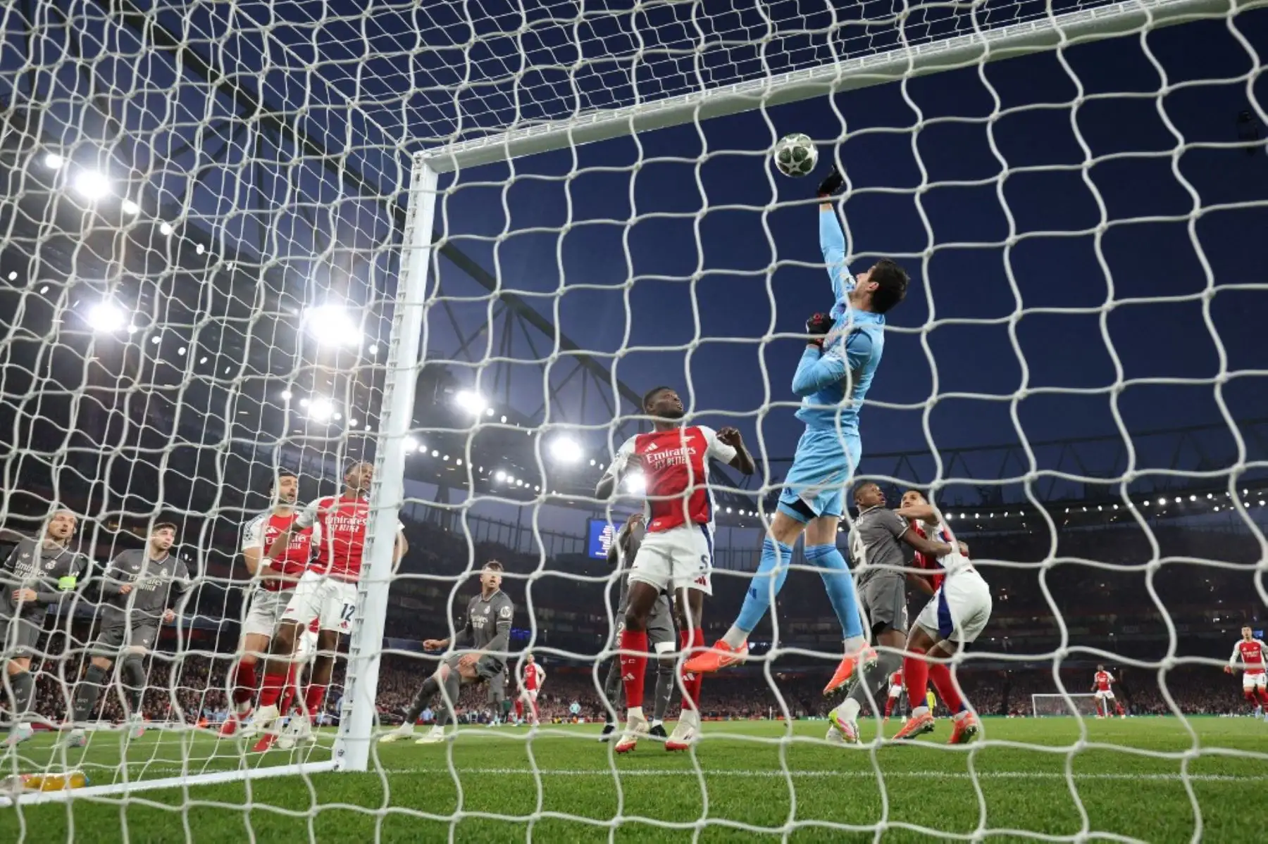 El portero belga del Real Madrid, Thibaut Courtois, despeja el balón con los puños durante el partido de ida de los cuartos de final de la Liga de Campeones de la UEFA entre el Arsenal y el Real Madrid, en el Emirates Stadium, en Londres, el 8 de abril de 2025. Foto: AFP
