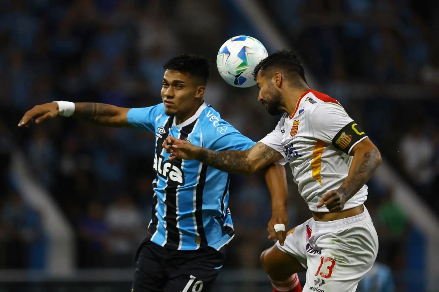 El delantero uruguayo de Gremio, Matías Arezo, y el defensor argentino de Atlético Grau, Daniel Franco, luchan por el balón durante el partido de fútbol de la fase de grupos de la Copa Sudamericana entre Gremio de Brasil y Atlético Grau de Perú en el estadio Arena do Gremio en Porto Alegre, Brasil, el 8 de abril de 2025. Foto: AFP