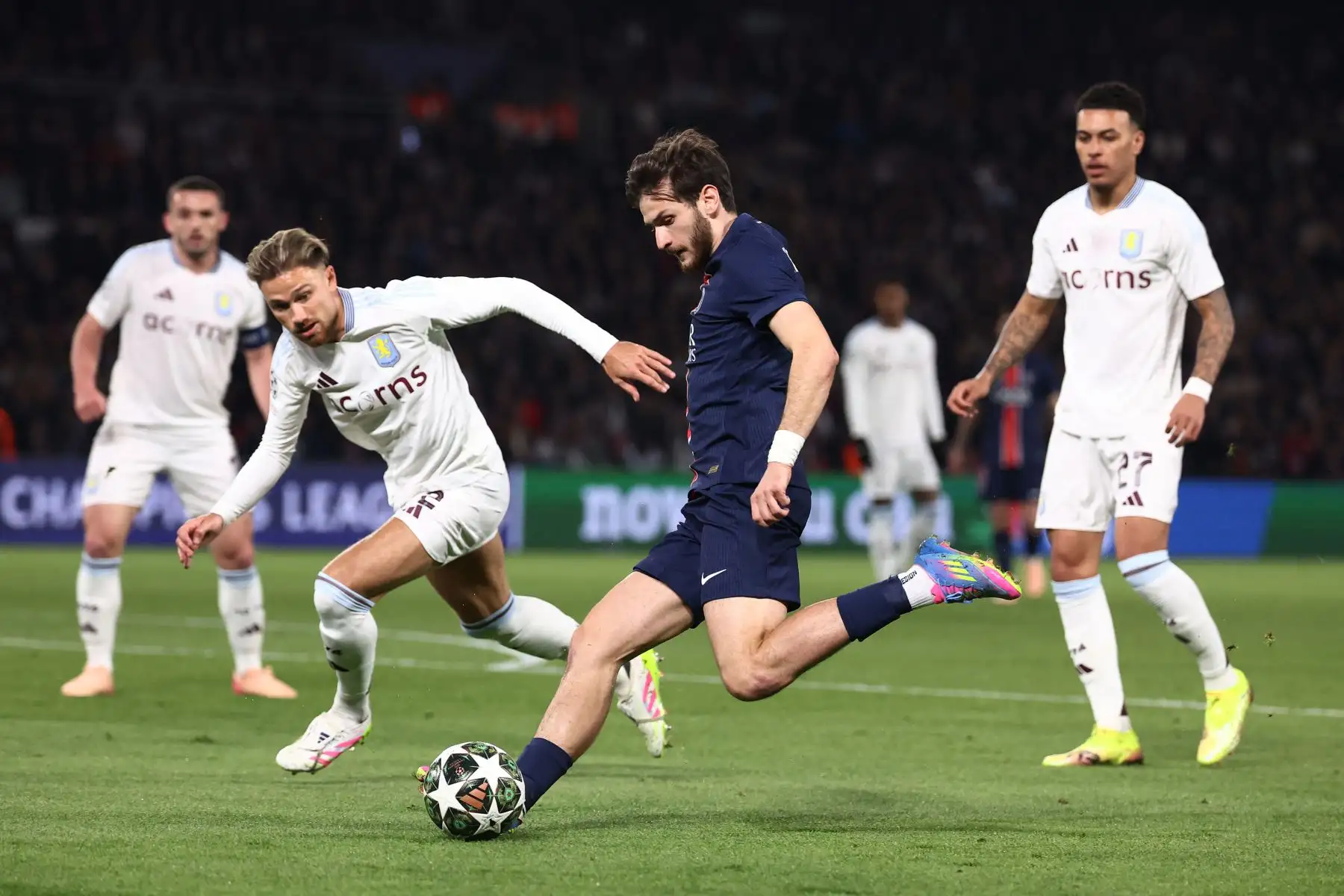 El delantero georgiano  del Paris Saint-Germain, Khvicha Kvaratskhelia, y el defensa polaco del Aston Villa, Matty Cash  luchan por el balón durante el partido de ida de los cuartos de final de la UEFA Champions League entre el Paris Saint-Germain y el Aston Villa. AFP