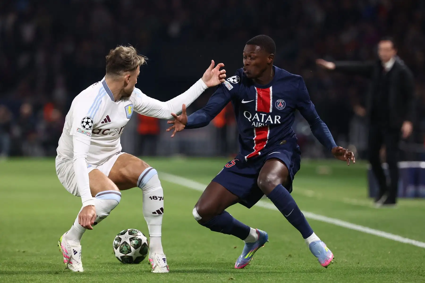 El defensa portugués  del Paris Saint-Germain, Nuno Mendes  y el defensa polaco del Aston Villa, Matty Cash, luchan por el balón durante el partido de ida de los cuartos de final de la UEFA Champions League entre el Paris Saint-Germain y el Aston Villa. AFP