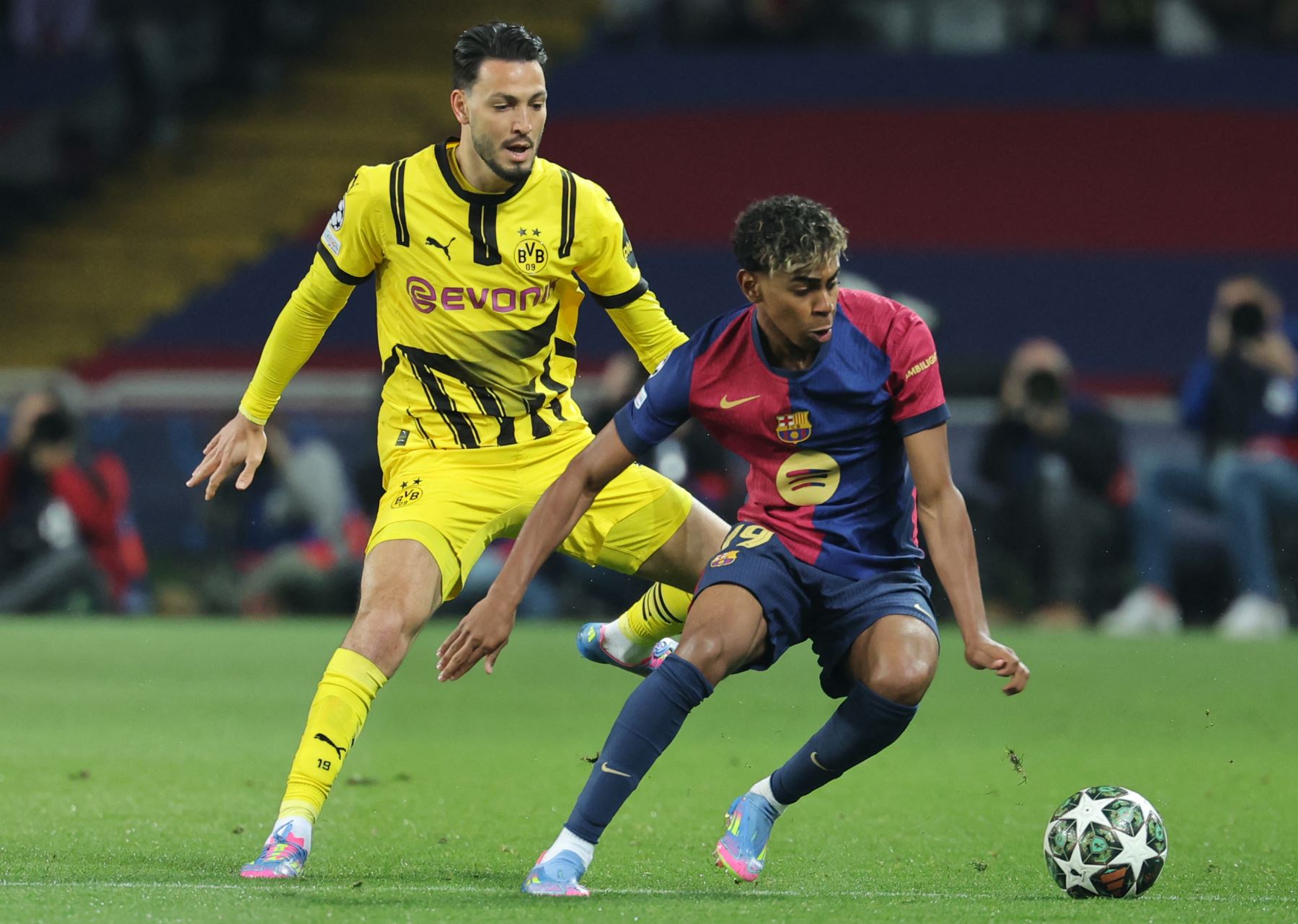 El defensa argelino  del Borussia Dortmund, Rami Bensebaini, y el delantero español  del Barcelona, ​​Lamine Yamal, luchan por el balón durante el partido de ida de los cuartos de final de la UEFA Champions League entre el FC Barcelona y el BVB Borussia Dortmund. Foto: AFP