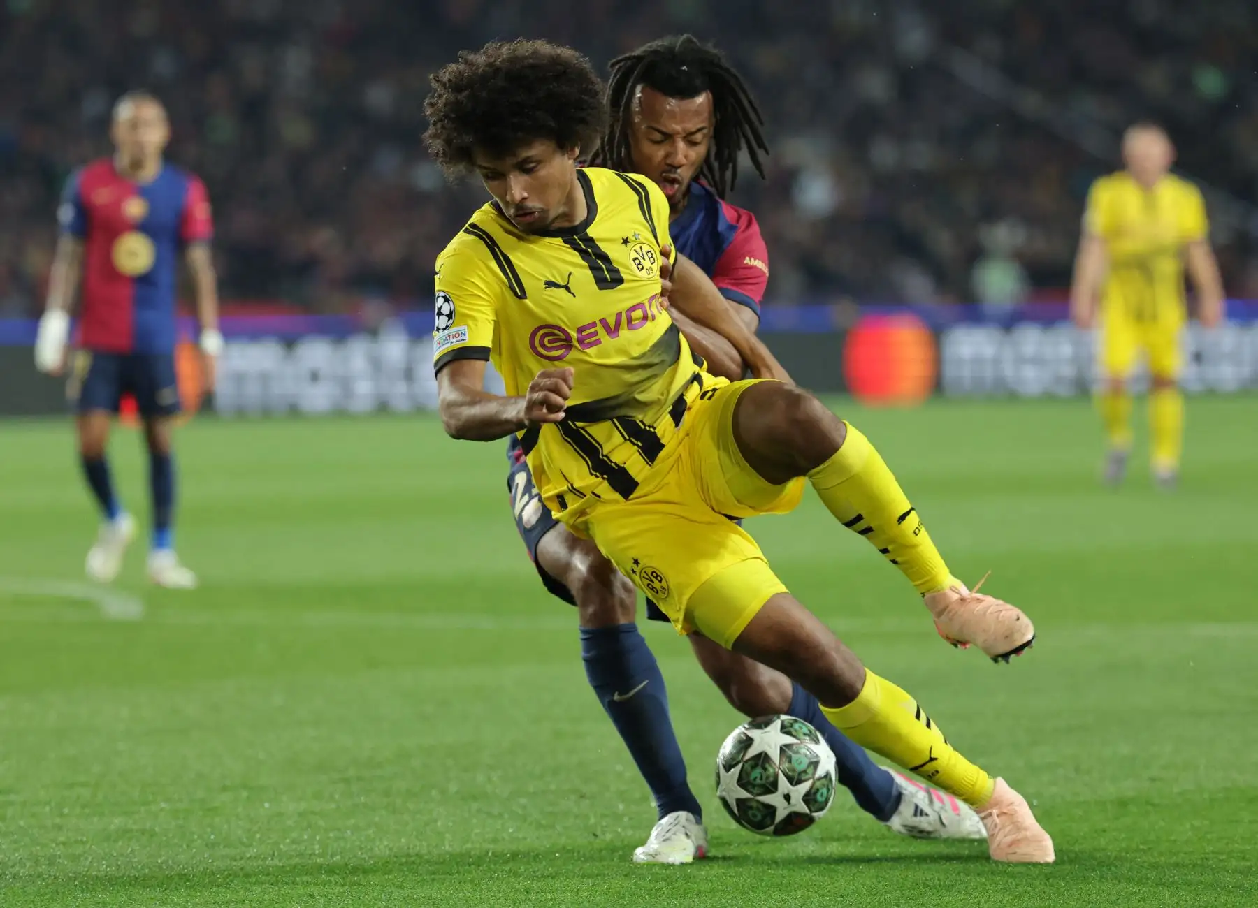El delantero alemán  del Borussia Dortmund, Karim Adeyemi, es desafiado por el defensa francés  del Barcelona, ​​Jules Kounde, durante el partido de ida de los cuartos de final de la UEFA Champions League entre el FC Barcelona y el BVB Borussia Dortmund. AFP