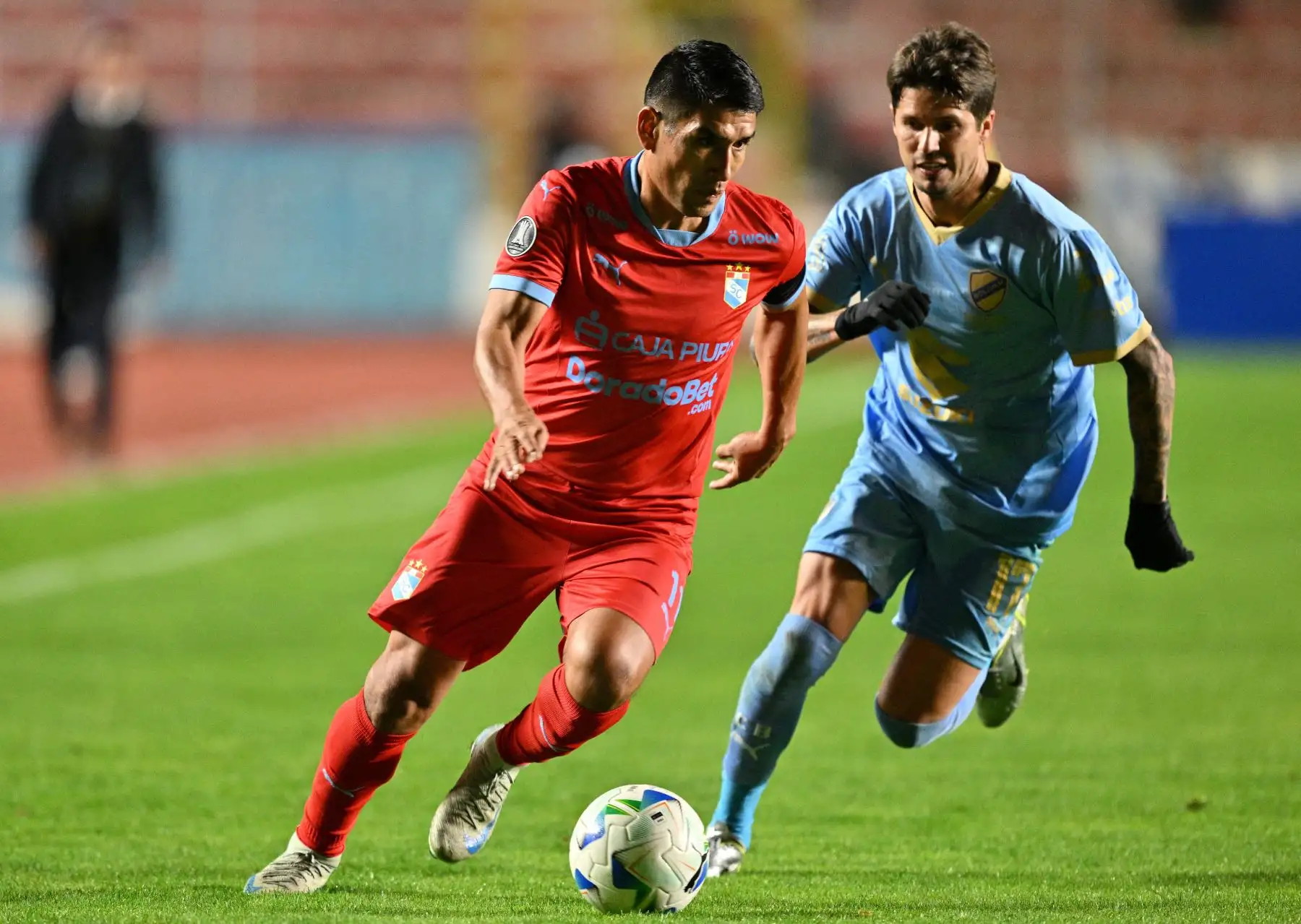 El delantero  de Sporting Cristal, Irven Ávila, y el delantero argentino  de Bolívar, Patricio Rodríguez, luchan por el balón durante el partido de fútbol de la fase de grupos de la Copa Libertadores entre Bolívar de Bolivia y Sporting Cristal de Perú. AFP