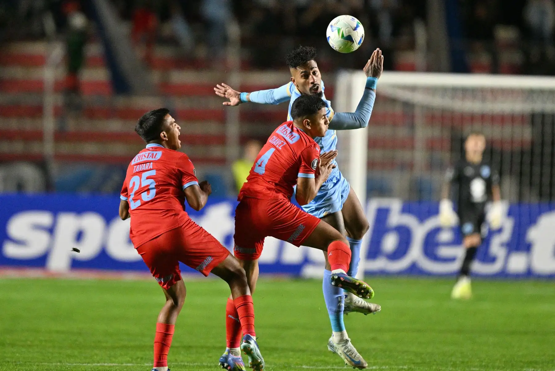 El delantero brasileño  de Bolívar, Fabio Gomes el defensor  de Sporting Cristal, Gianfranco Chávez, y el mediocampista  Martín Tavara luchan por el balón durante el partido de fútbol de la fase de grupos de la Copa Libertadores entre Bolívar de Bolivia y Sporting Cristal de Perú. AFP