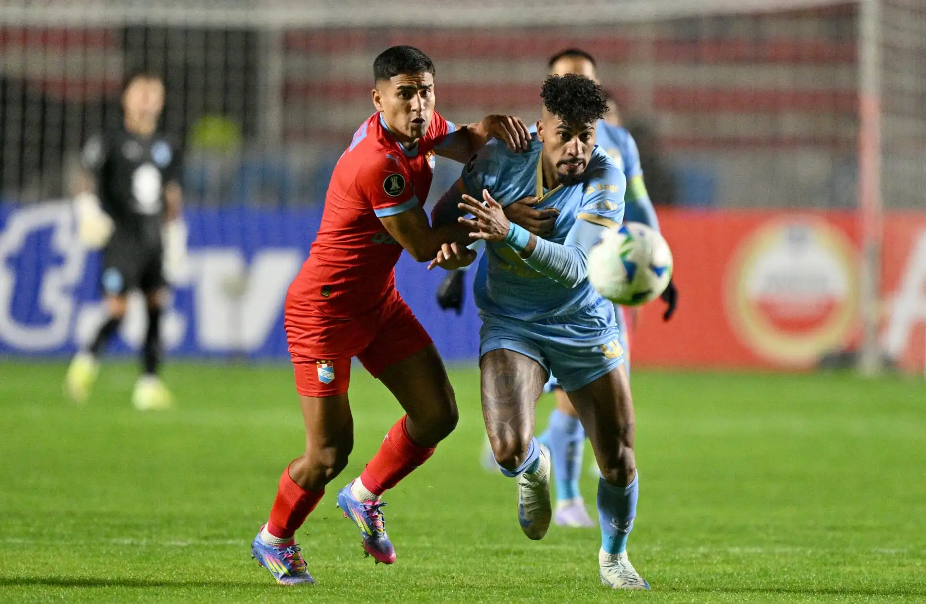 El defensa de Sporting Cristal, Gianfranco Chávez y el delantero brasileño de Bolívar, Fabio Gomes, luchan por el balón durante el partido de fútbol de la fase de grupos de la Copa Libertadores entre Bolívar de Bolivia y Sporting Cristal de Perú. AFP