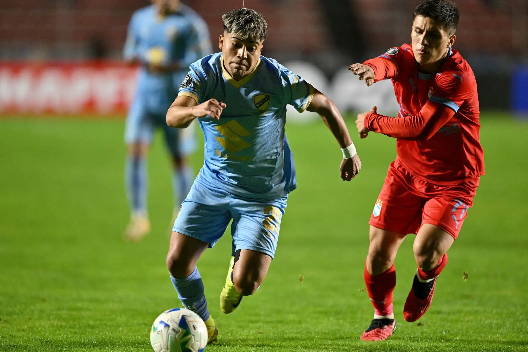El defensa de Bolívar, Jhon Velásquez, y el mediocampista de Sporting Cristal, Catriel Cabellos, luchan por el balón durante el partido de la fase de grupos de la Copa Libertadores entre Bolívar de Bolivia y Sporting Cristal de Perú . AFP