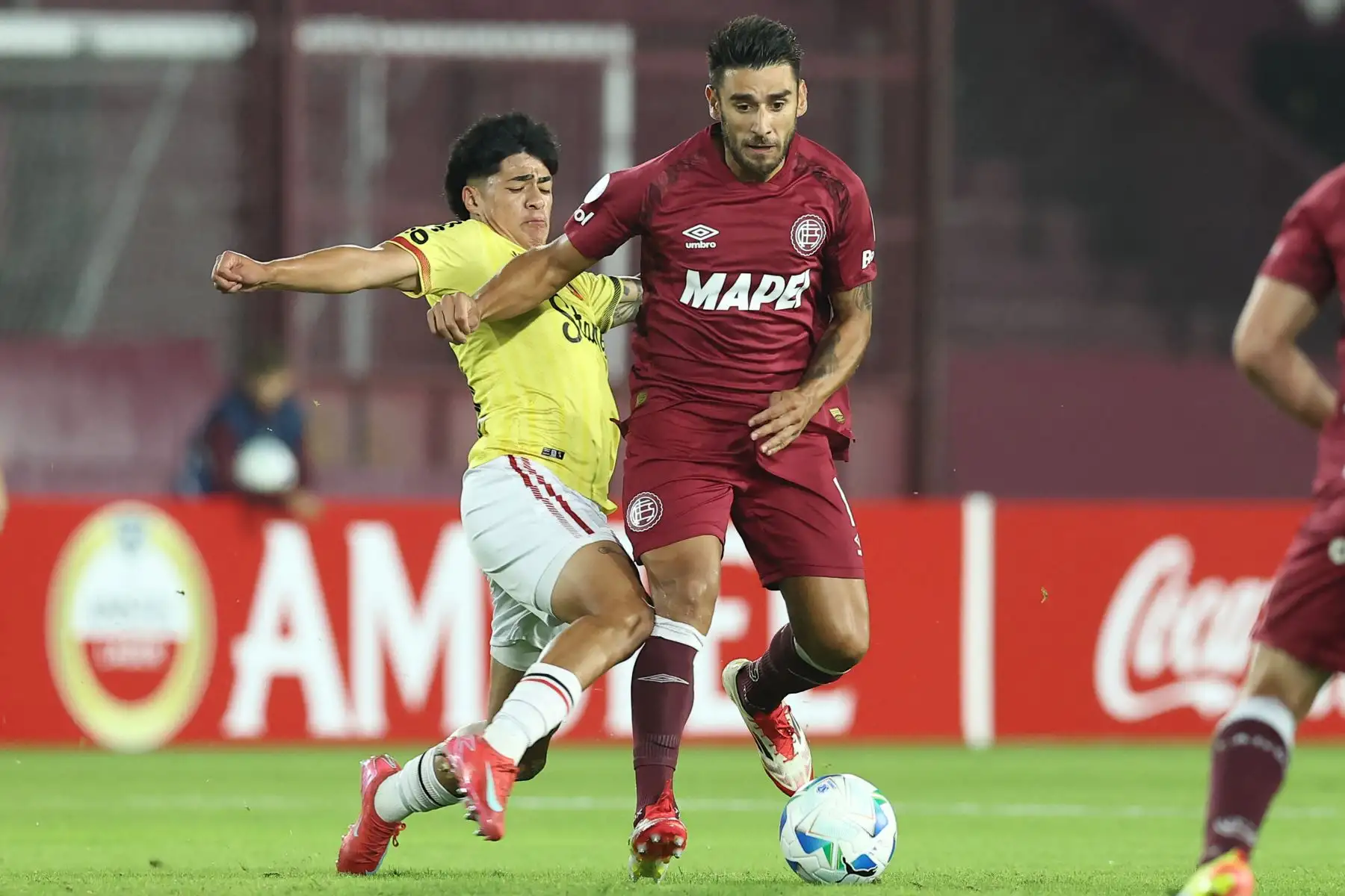 El mediocampista de Melgar  Kenji Cabrera y el mediocampista de Lanus Eduardo Salvio pelean por el balón durante el partido de fútbol de la fase de grupos de la Copa Sudamericana entre Lanus de Argentina y Melgar de Perú. Foto: AFP