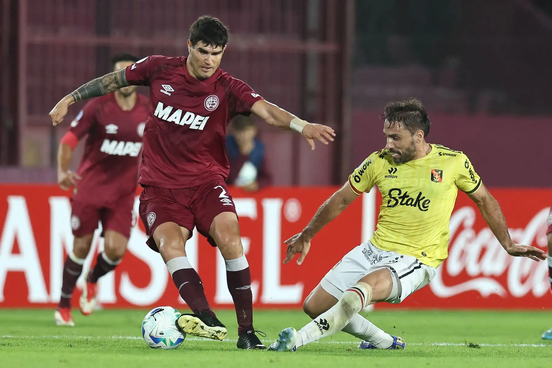 El defensa  de Lanús, Ezequiel Muñoz, y el delantero argentino  de Melgar, Cristian Bordacahar, luchan por el balón durante el partido de la fase de grupos de la Copa Sudamericana entre Lanús de Argentina y Melgar de Perú. AFP