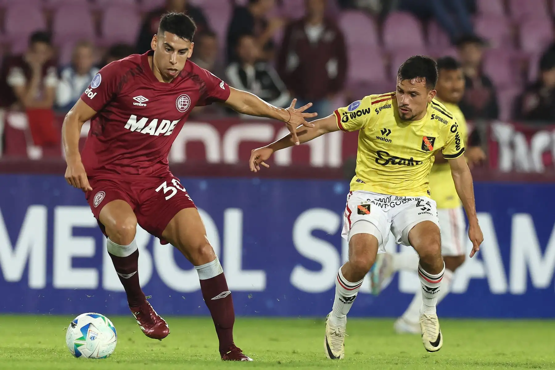 El mediocampista  de Lanús, Agustín Cardozo, y el mediocampista  de Melgar, Walter Tandazo, luchan por el balón durante el partido de la fase de grupos de la Copa Sudamericana entre Lanús de Argentina y Melgar de Perú. AFP