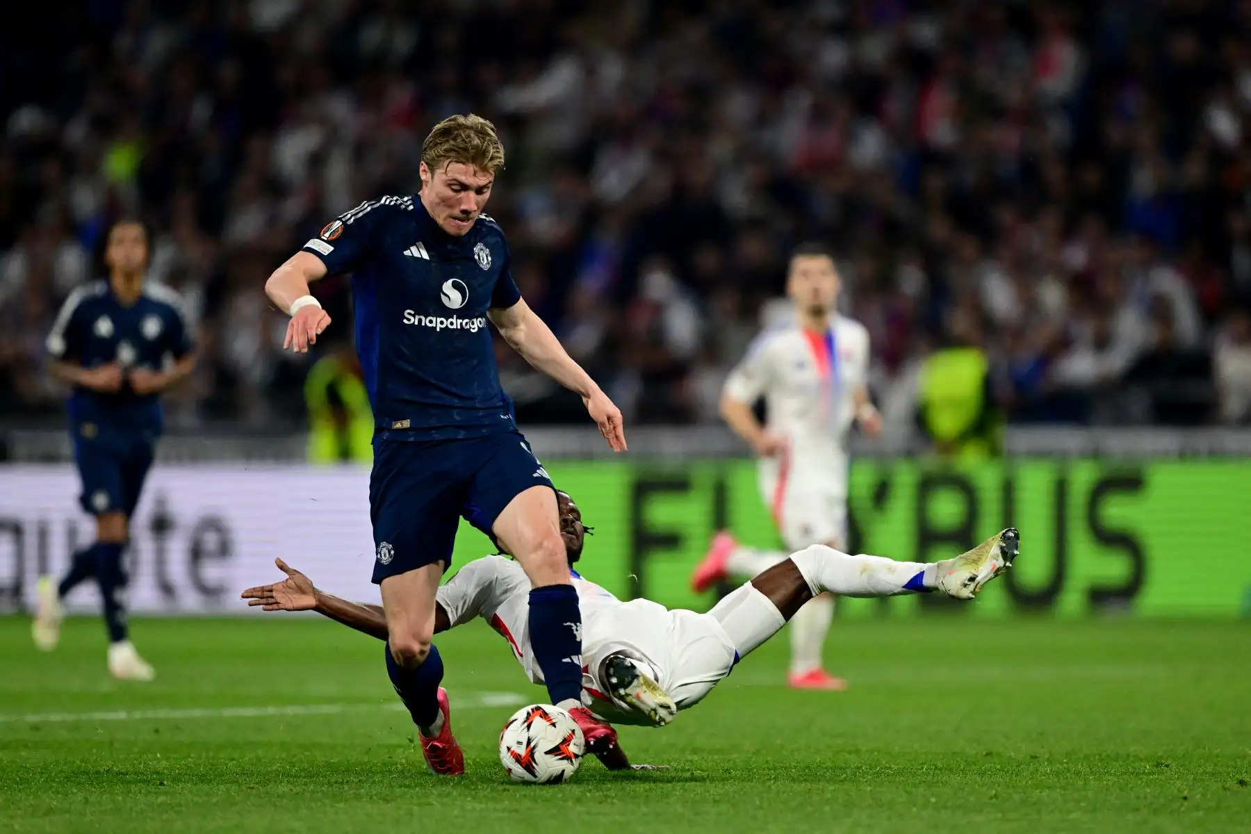 El delantero danés del Manchester United, Rasmus Hojlund , lucha por el balón con el defensa angoleño del Lyon, Clinton Mata, entre el Olympique Lyonnais  durante el partido de ida de los cuartos de final de la UEFA Europa League entre el Olympique Lyonnais  y el Manchester United. AFP