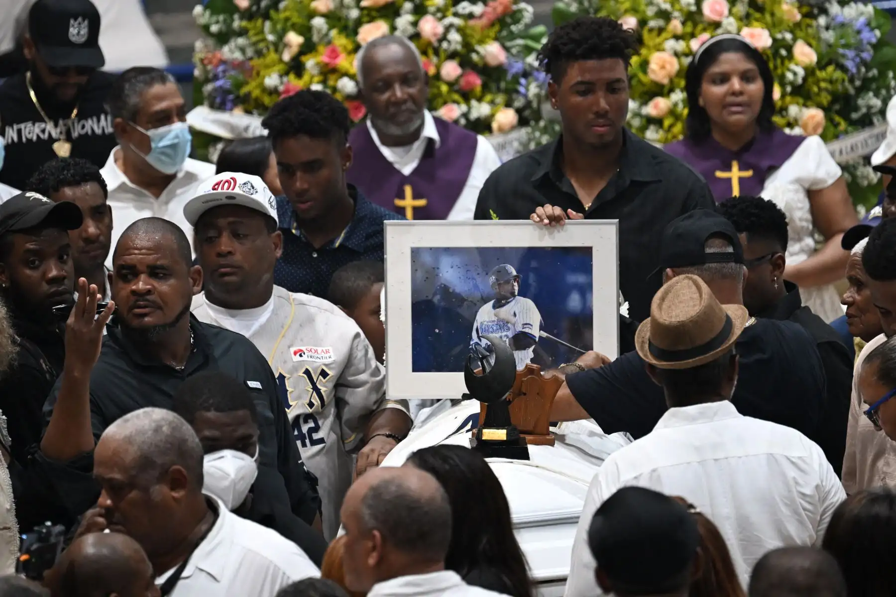 Familiares y amigos lloran junto al féretro del ex beisbolista dominicano Tony Blanco -quien falleció en el derrumbe del techo de la discoteca Jet Set- durante un funeral multitudinario en el Polideportivo de Bajos de Haina, Santo Domingo. AFP