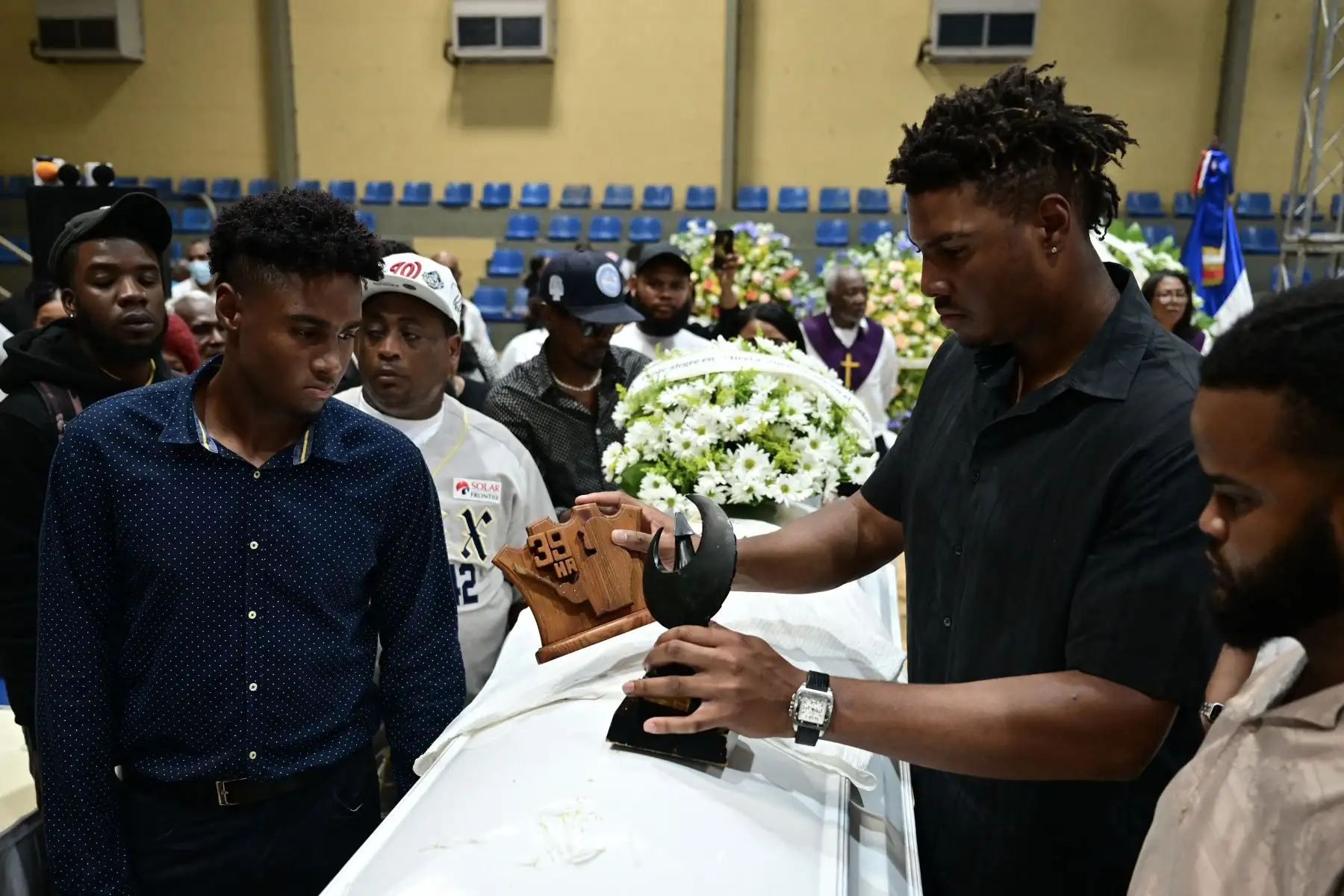 Familiares y amigos lloran junto al féretro del ex beisbolista dominicano Tony Blanco -quien falleció en el derrumbe del techo de la discoteca Jet Set- durante un funeral multitudinario en el Polideportivo de Bajos de Haina, Santo Domingo. AFP