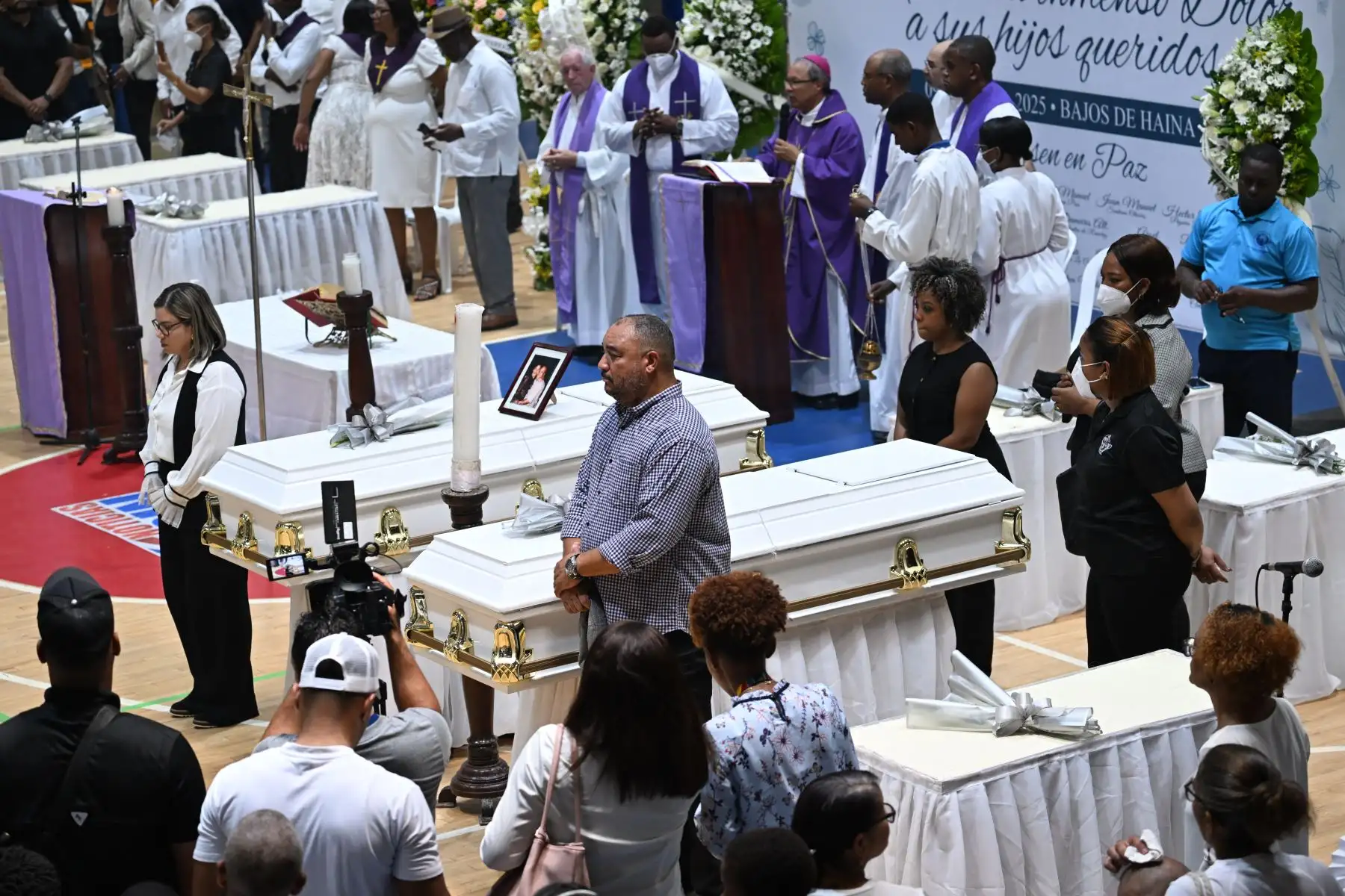 Familiares y amigos de algunas de las víctimas del derrumbe del techo de la discoteca Jet Set asisten a un funeral multitudinario en el Polideportivo de Bajos de Haina, Santo Domingo. AFP