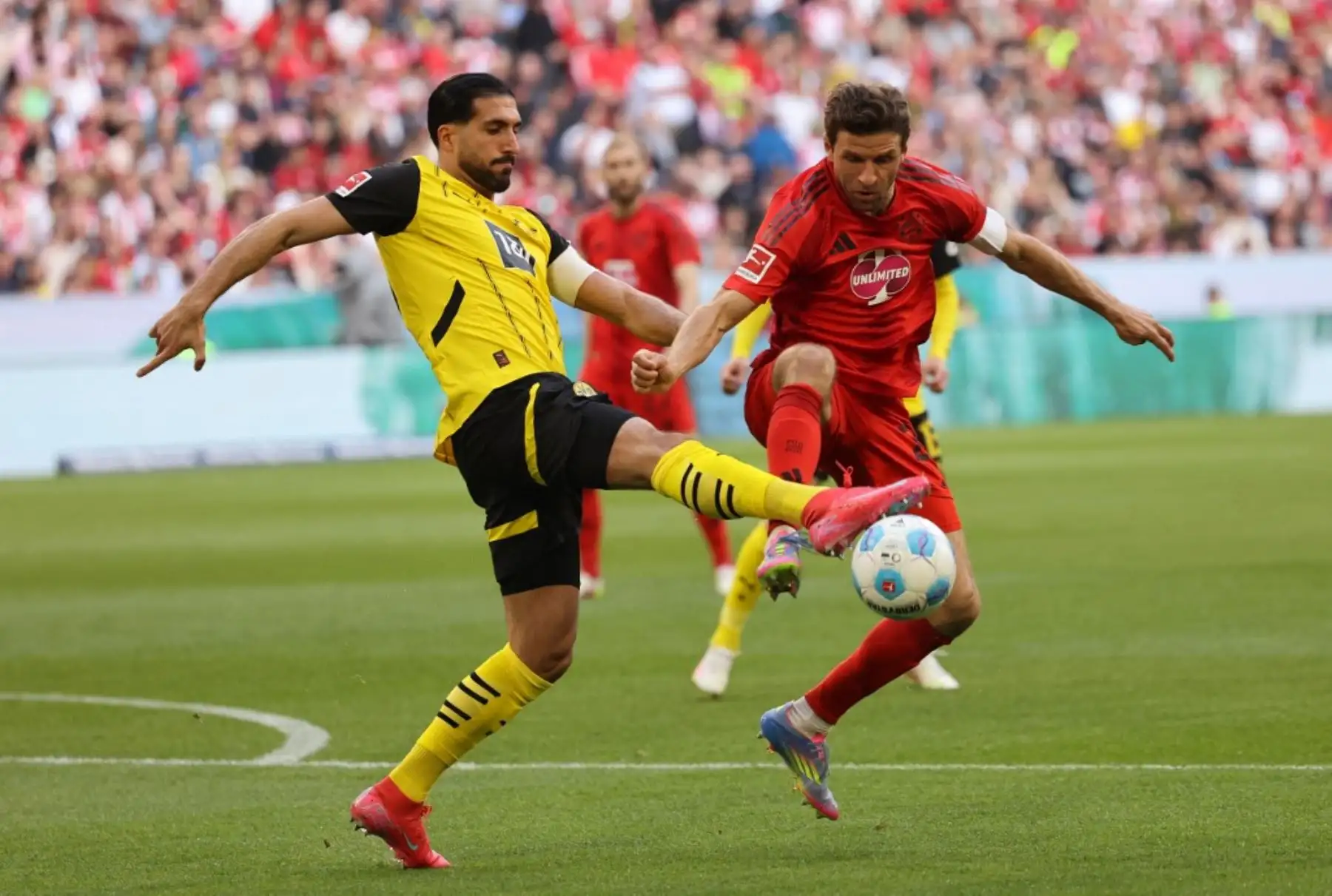 El centrocampista alemán del Dortmund, Emre Can, y el delantero alemán del Bayern Munich, Thomas Mueller, compiten por el balón durante el partido de fútbol de la Bundesliga, entre el Bayern Munich y el Borussia Dortmund en Munich, sur de Alemania, el 12 de abril de 2025. Foto: AFP