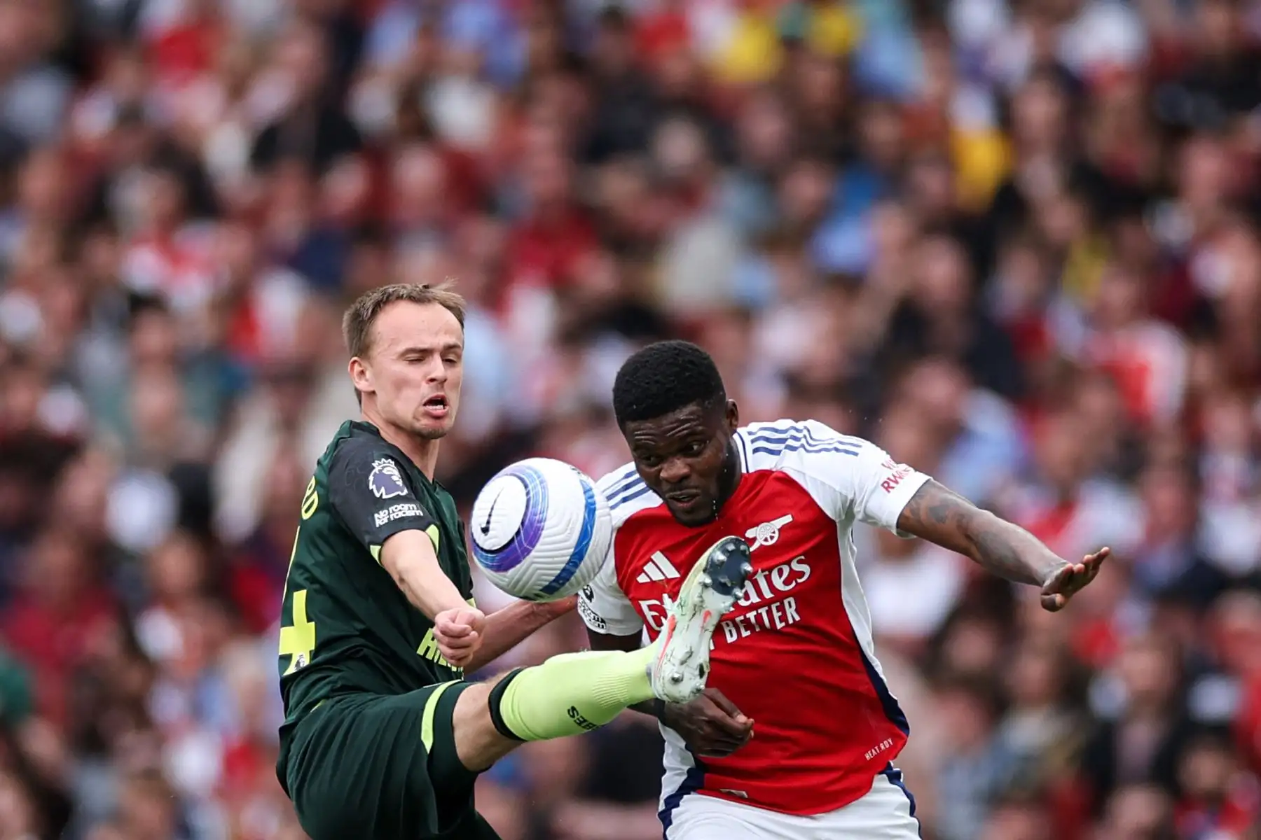 El centrocampista danés del Brentford, Mikkel Damsgaard, lucha por el balón con el centrocampista ghanés del Arsenal, Thomas Partey, durante el partido de fútbol de la Premier League inglesa entre Arsenal y Brentford en el Emirates Stadium en Londres el 12 de abril de 2025. Foto: AFP