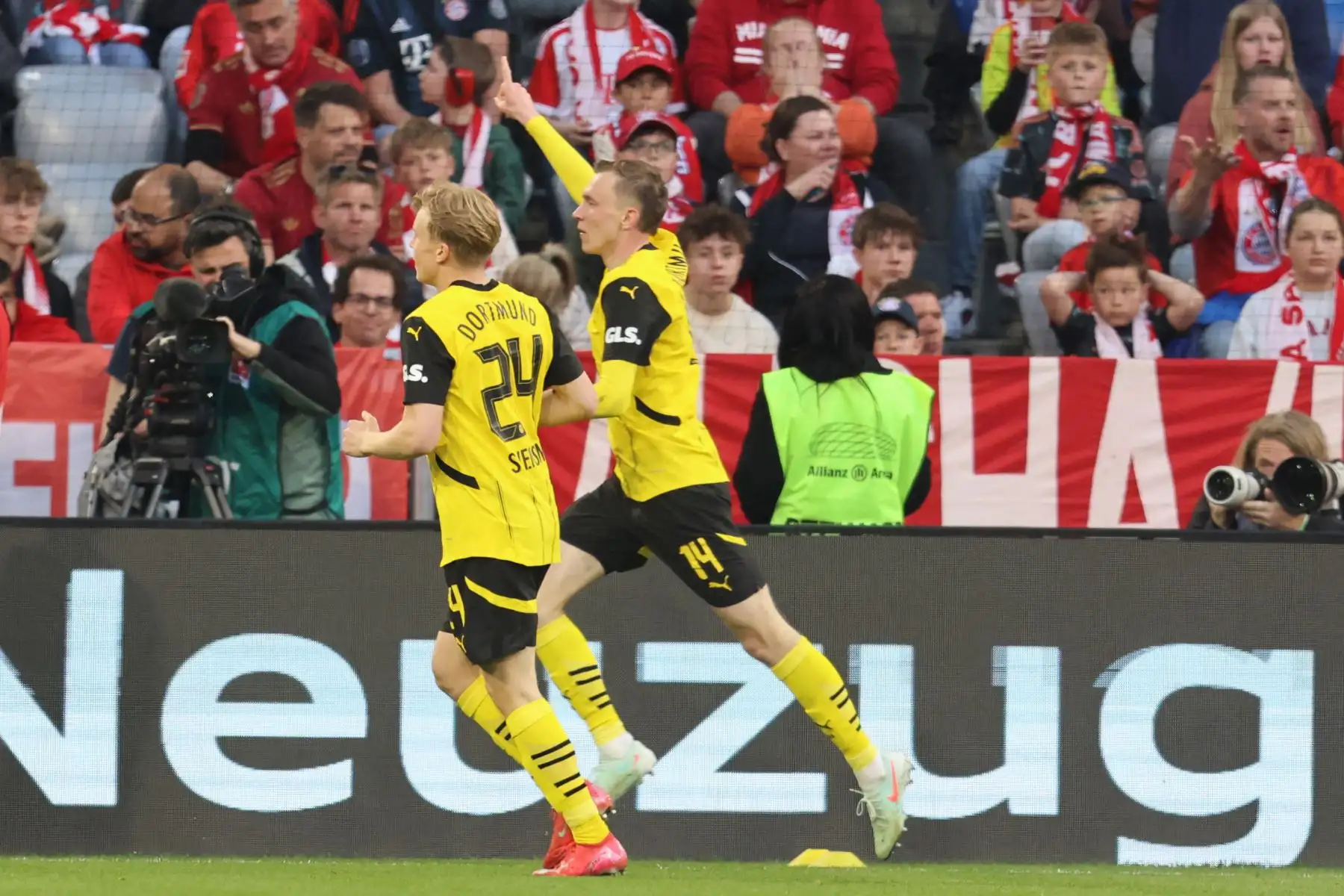 El delantero alemán del Dortmund, Maximilian Beier, celebra con el defensor sueco Daniel Svensson el primer gol durante el partido de fútbol de la primera división alemana, la Bundesliga, entre el Bayern Munich y el Borussia Dortmund en Munich, sur de Alemania, el 12 de abril de 2025. Foto: AFP