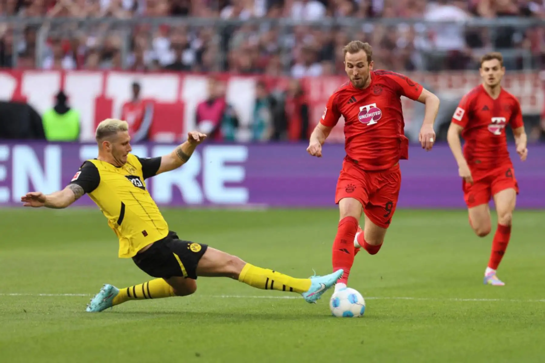 El defensor alemán del Dortmund, Niklas Süle, y el delantero inglés del Bayern Munich, Harry Kane, compiten por el balón durante el partido de fútbol de la Bundesliga, entre el Bayern Munich y el Borussia Dortmund en Munich, sur de Alemania, el 12 de abril de 2025. Foto: AFP