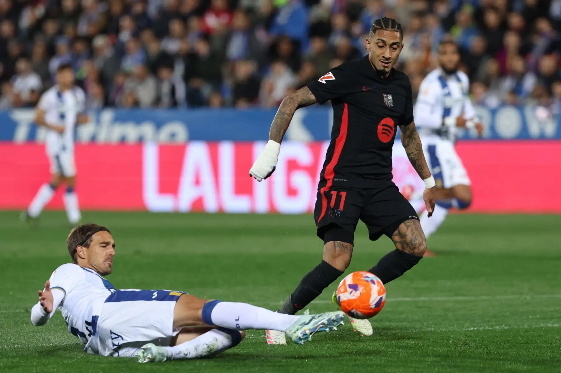 El defensa español del Leganés, Sergio González, se enfrenta al delantero brasileño del Barcelona, ​​Raphinha, durante el partido de la liga española entre el Club Deportivo Leganés SAD y el FC Barcelona. Foto: ANDINA/AFP
