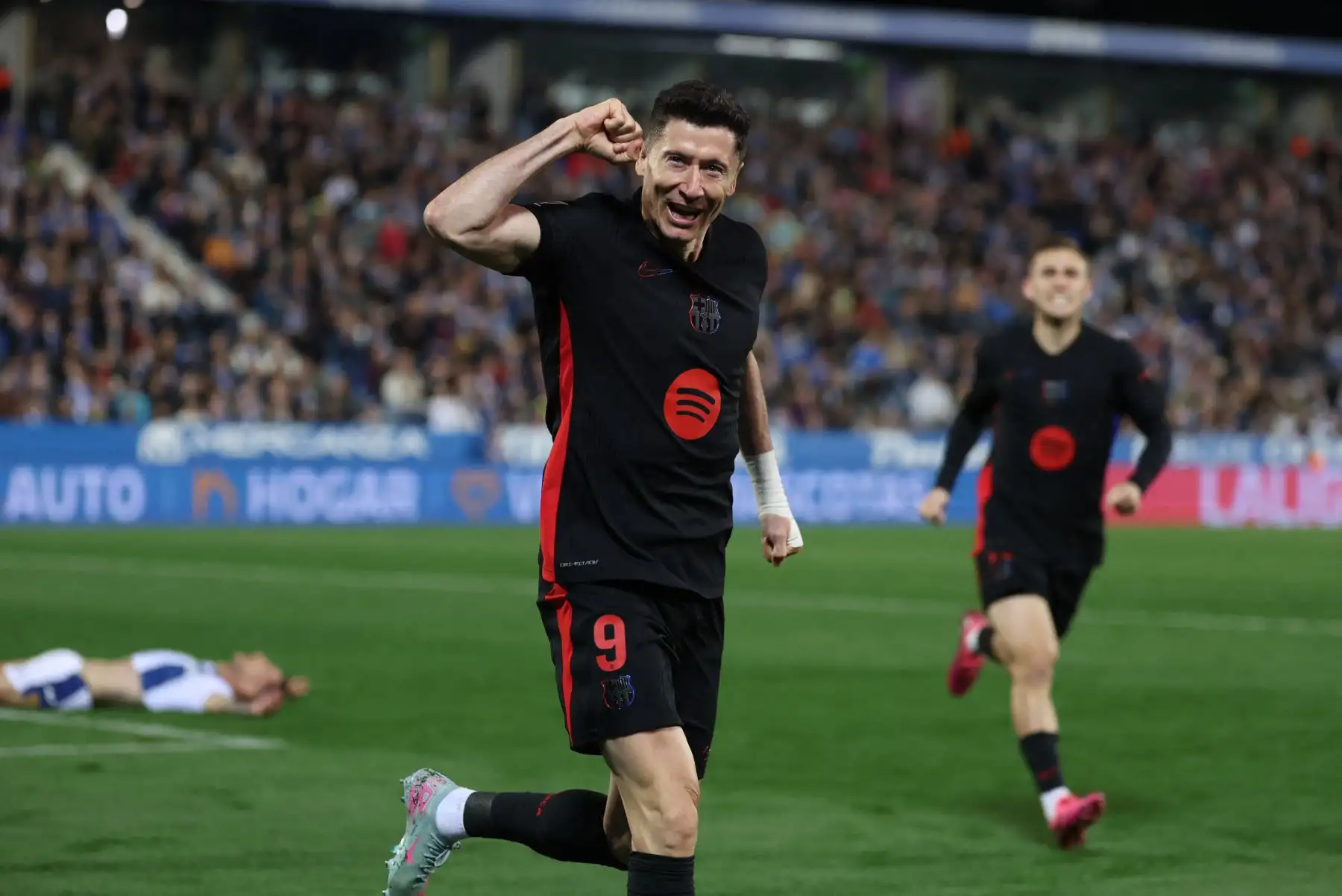 El delantero polaco del Barcelona, ​​Robert Lewandowski, celebra después de que el defensa español del Leganés, Jorge Sáenz, anotara un autogol durante el partido de la liga española entre el Club Deportivo Leganés SAD y el FC Barcelona. Foto: ANDINA/AFP