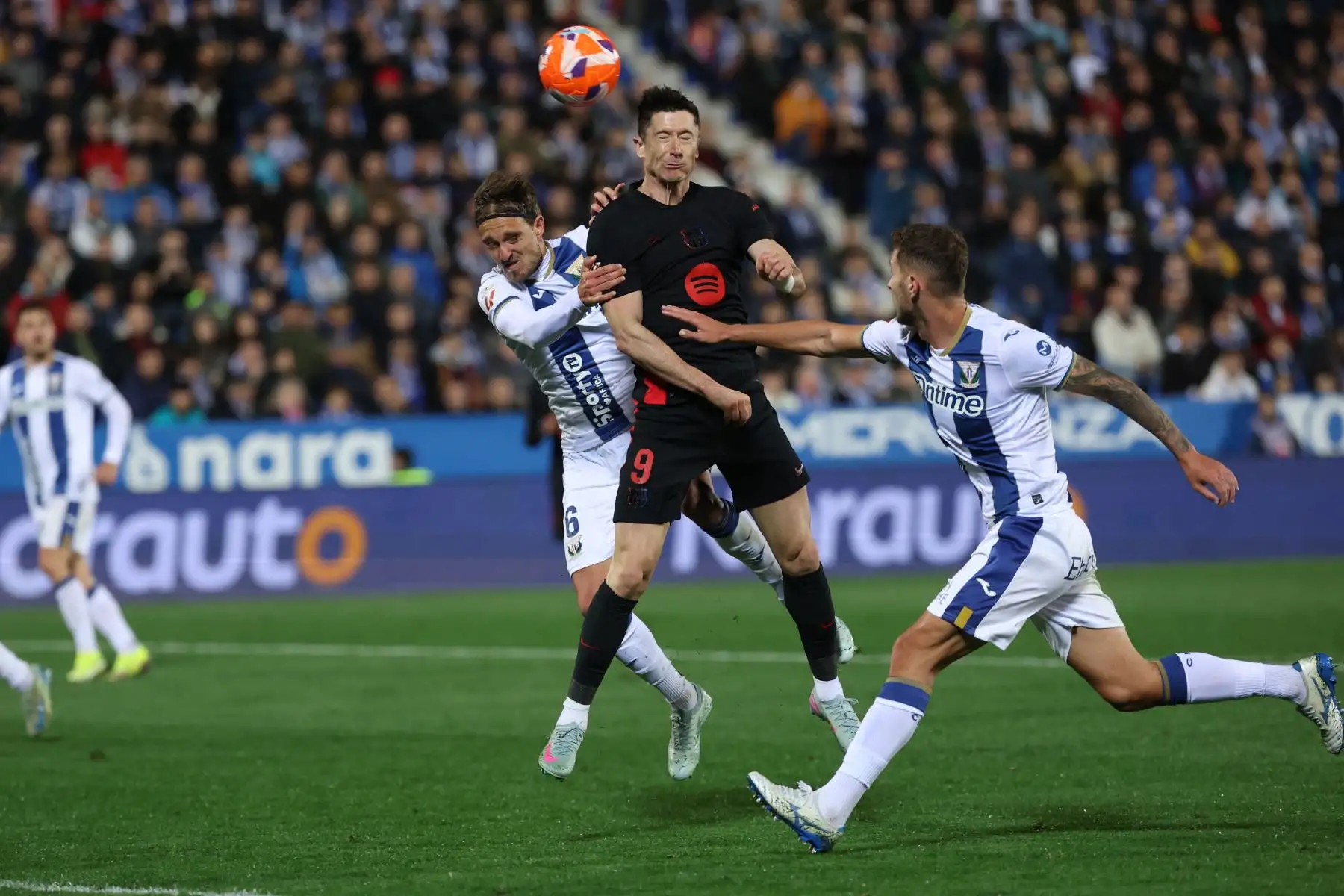 El delantero polaco del Barcelona, ​​Robert Lewandowski, intenta un cabezazo con el defensa español del Leganés, Sergio González, y el defensa español del Leganés, Jorge Sáenz, durante el partido de la liga española entre el Club Deportivo Leganés SAD y el FC Barcelona. Foto. ANDINA/AFP