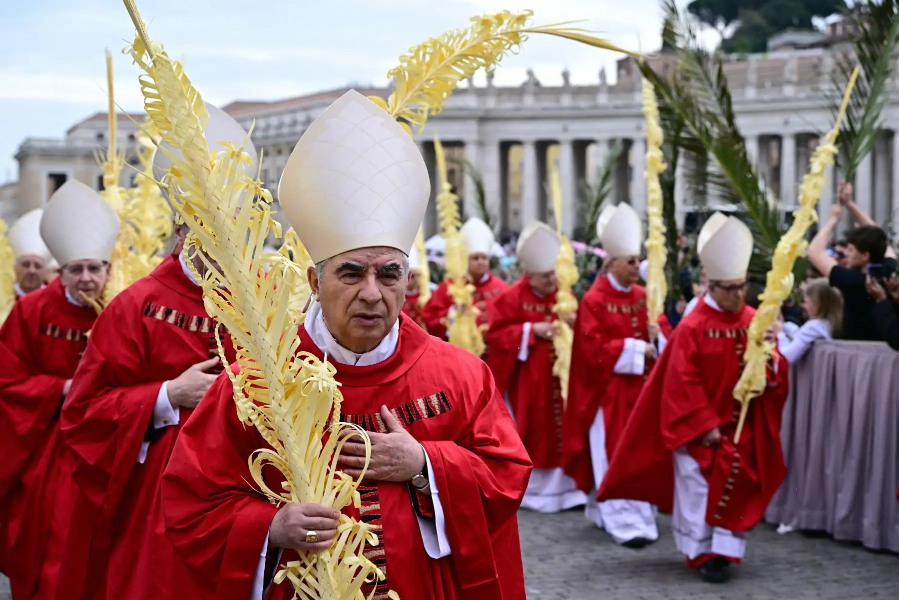 El cardenal Angelo Becciu camina en procesión durante la misa del Domingo de Ramos en la plaza de San Pedro del Vaticano. Foto: ANDINA/AFP