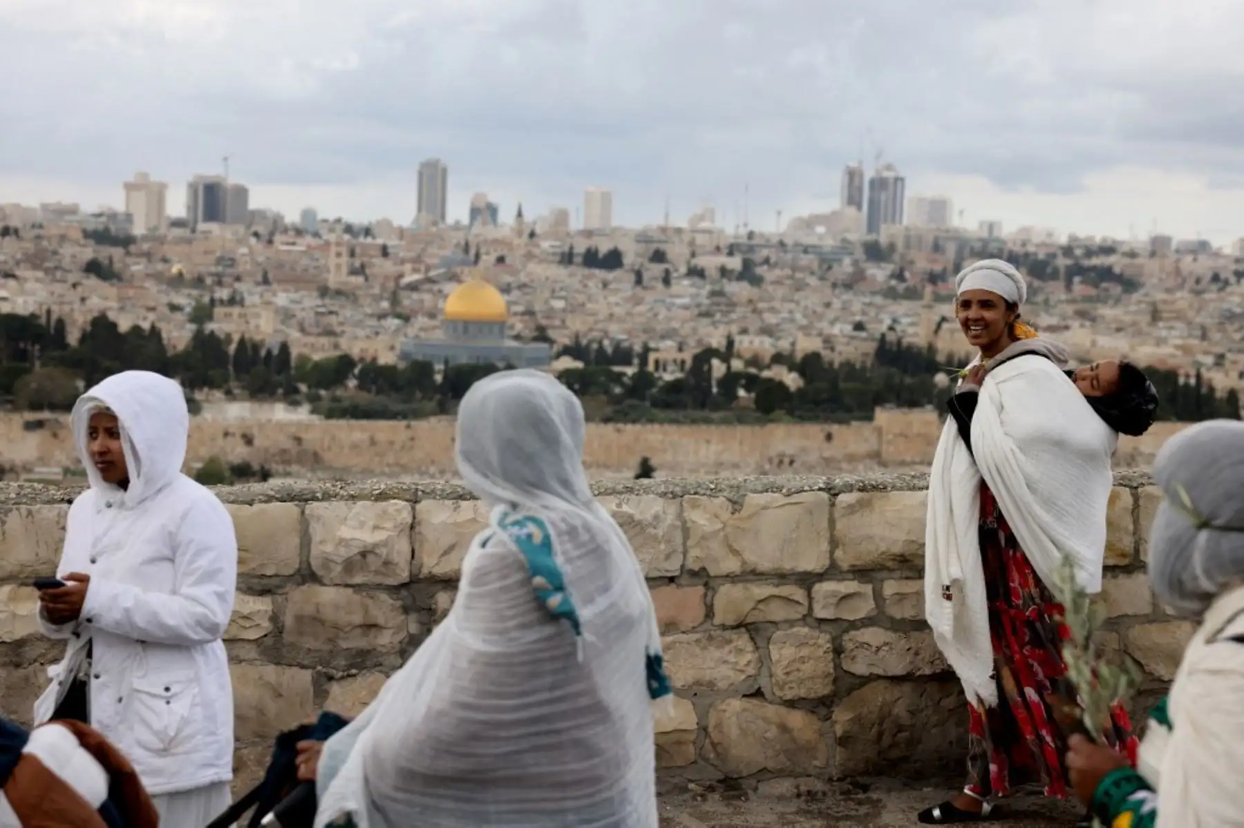 Los fieles cristianos marchan por una calle con vistas al complejo de la mezquita Al-Aqsa, durante la tradicional procesión del Domingo de Ramos en el Monte de los Olivos en Jerusalén, Israel, el 13 de abril de 2025. Foto: AFP