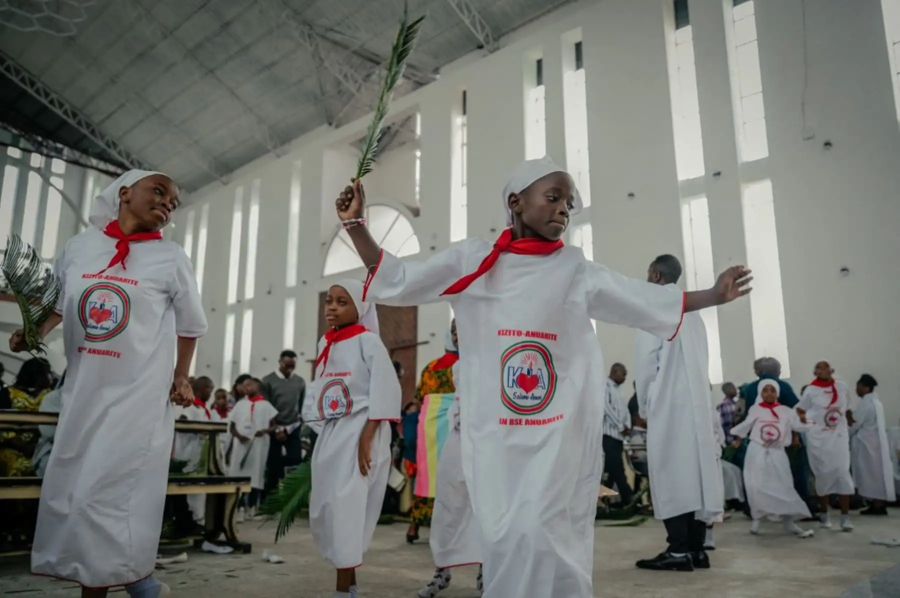 Jóvenes bailarines litúrgicos católicos actúan durante la misa del Domingo de Ramos, conocida localmente como Matawi, en la parroquia Bienheureuse en Goma, en el país africano del Congo, el 13 de abril de 2025. Foto: AFP