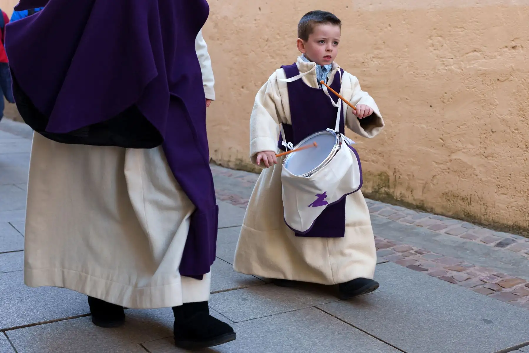 Davinia Temprano camina con su hijo Thiago antes de participar por primera vez en la procesión de la hermandad de Jesús del Vía Crucis durante las celebraciones de Semana Santa en la ciudad de Zamora, España. Foto: AFP