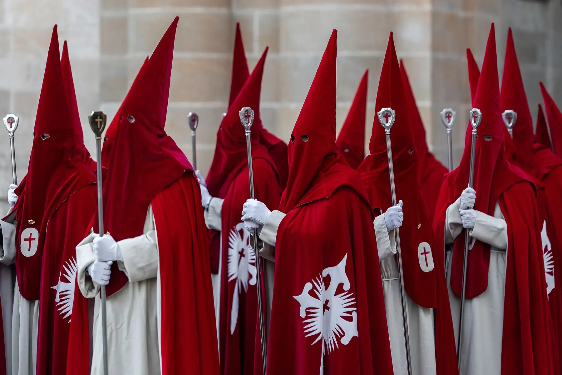 Miembros de la Real Hermandad del Santísimo Cristo de las Injurias se encuentran fuera de la catedral para hacer voto de silencio antes de participar en la Procesión del Silencio del Miércoles Santo. AFP