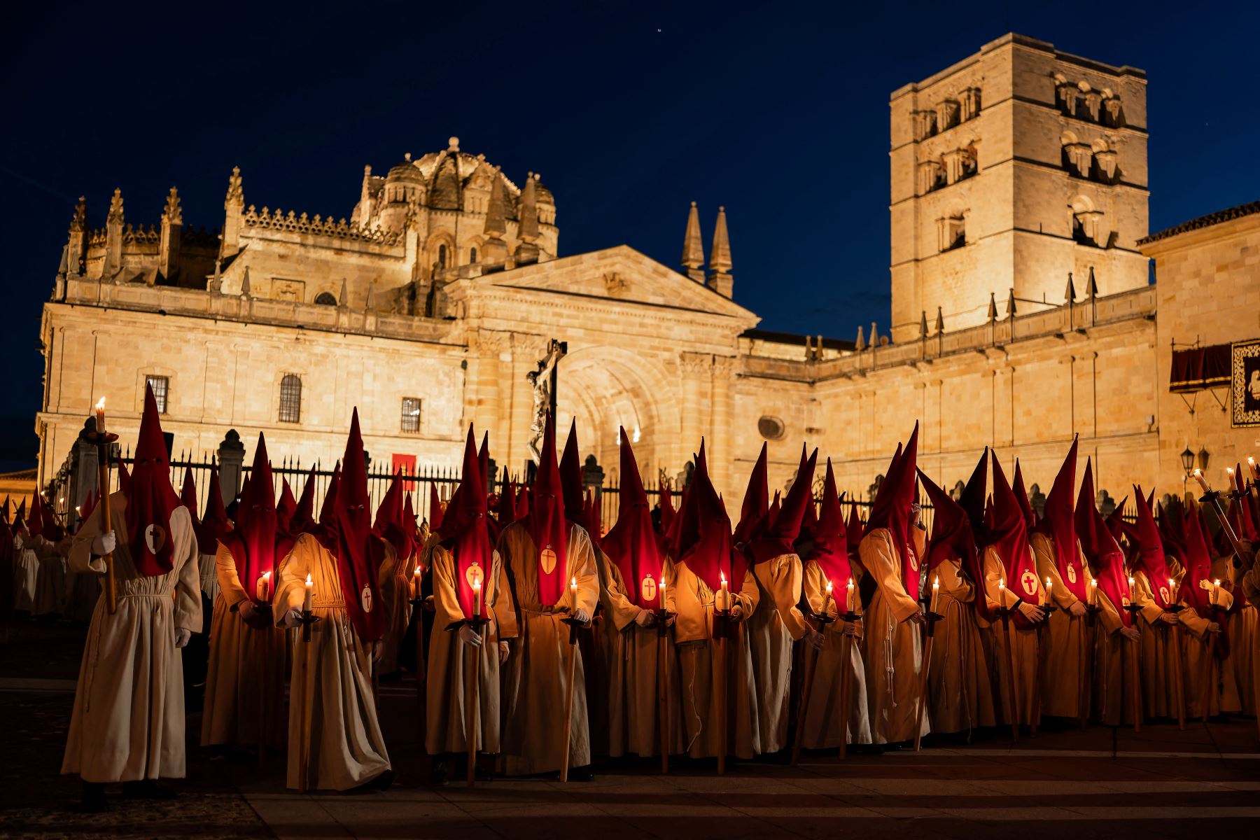 Miembros de la Real Hermandad del Santísimo Cristo de las Injurias se encuentran fuera de la catedral para hacer voto de silencio antes de participar en la Procesión del Silencio del Miércoles Santo. AFP