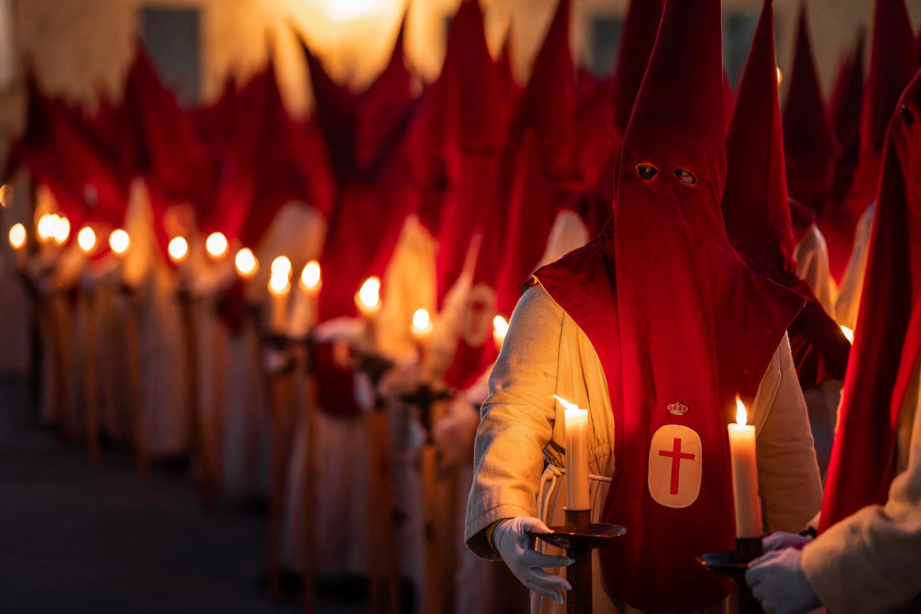 Miembros de la Real Hermandad del Santísimo Cristo de las Injurias se encuentran fuera de la catedral para hacer voto de silencio antes de participar en la Procesión del Silencio del Miércoles Santo. AFP