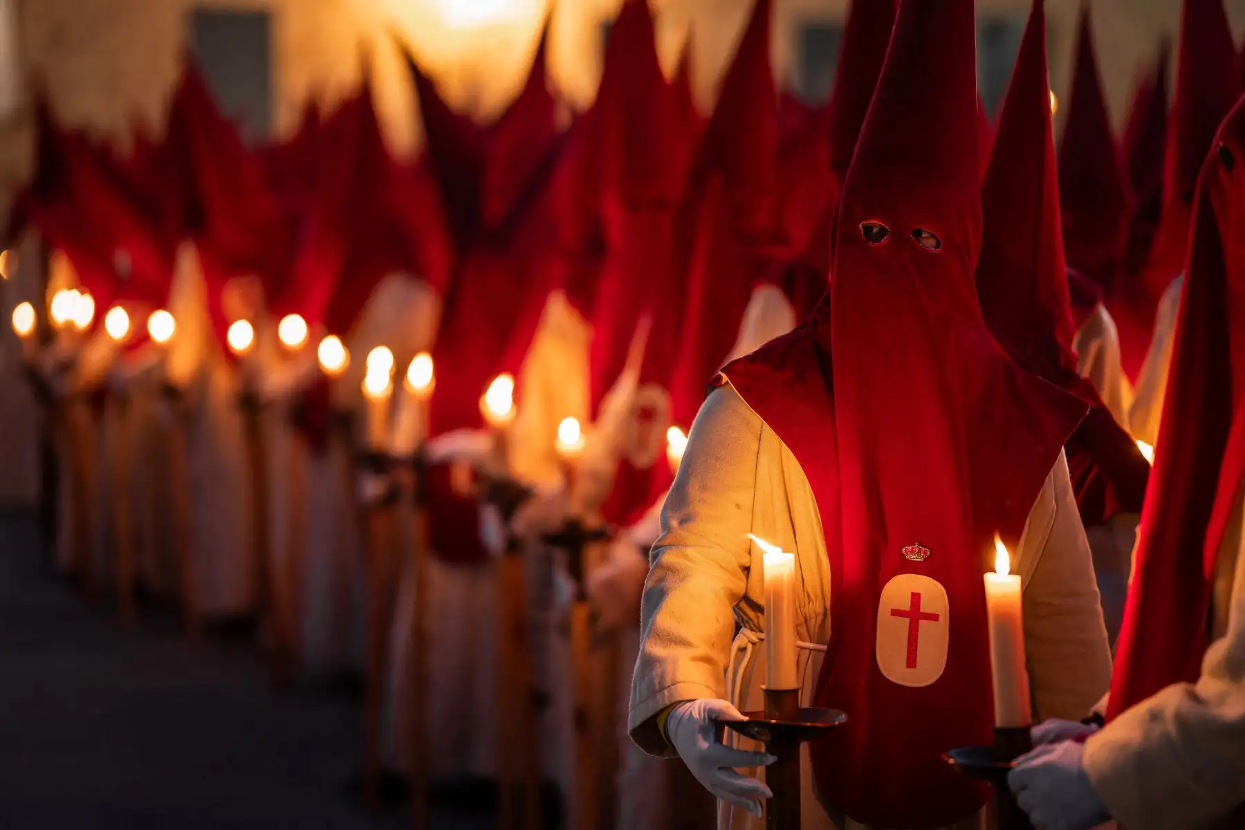 Miembros de la Real Hermandad del Santísimo Cristo de las Injurias se encuentran fuera de la catedral para hacer voto de silencio antes de participar en la Procesión del Silencio del Miércoles Santo. AFP