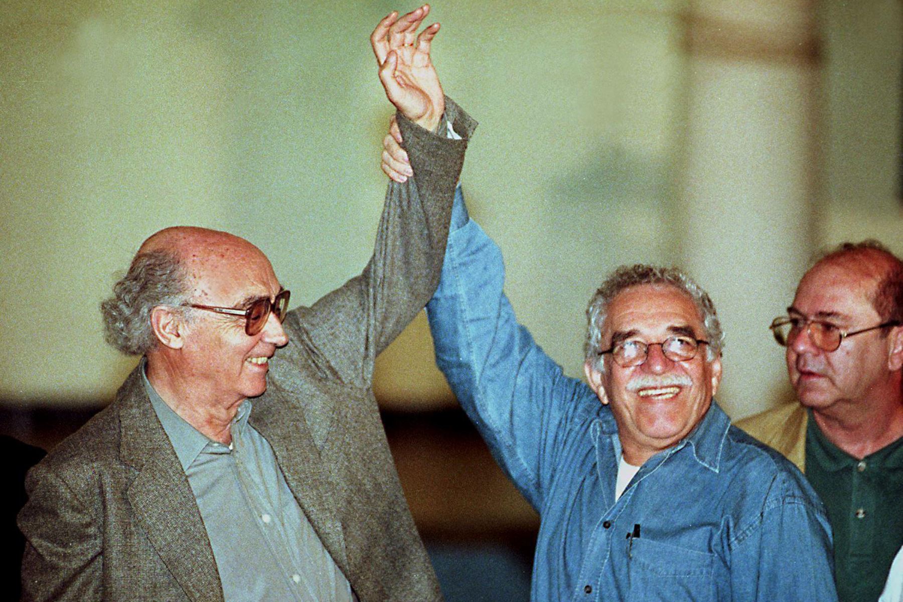 El premio Nobel de Literatura colombiano Gabriel García Márquez evanta el brazo de otro premio Nobel de literatura, José Saramago de Portugal, el 1 de enero en Santiago de Cuba, a unos 900 kilómetros al este de La Habana, durante la conmemoración del 40 aniversario de la revolución cubana. AFP