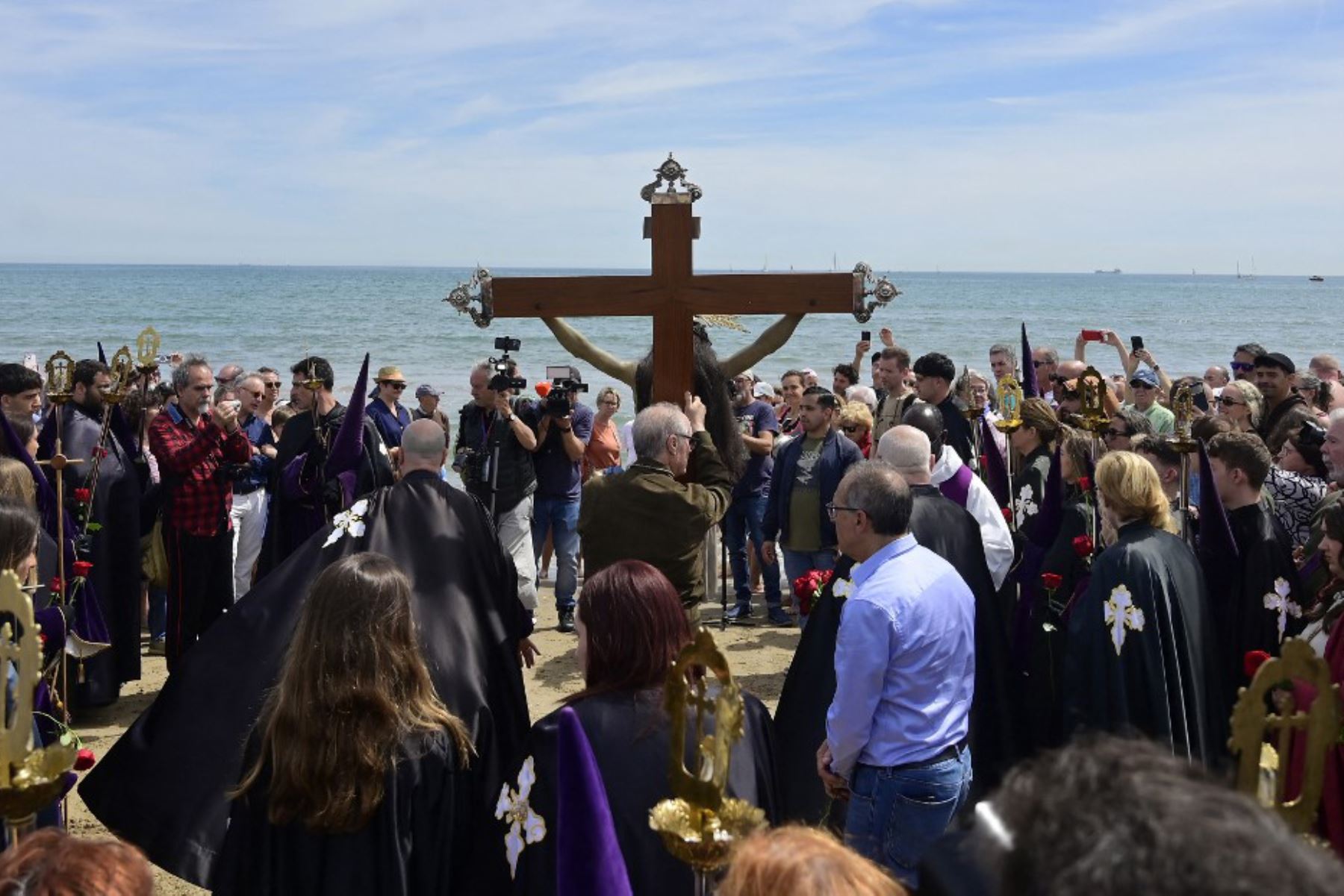 Penitentes de la cofradía del Cristo Salvador y del Amparo portan una cruz durante la procesión de Semana Santa en la playa de Valencia. Foto: AFP