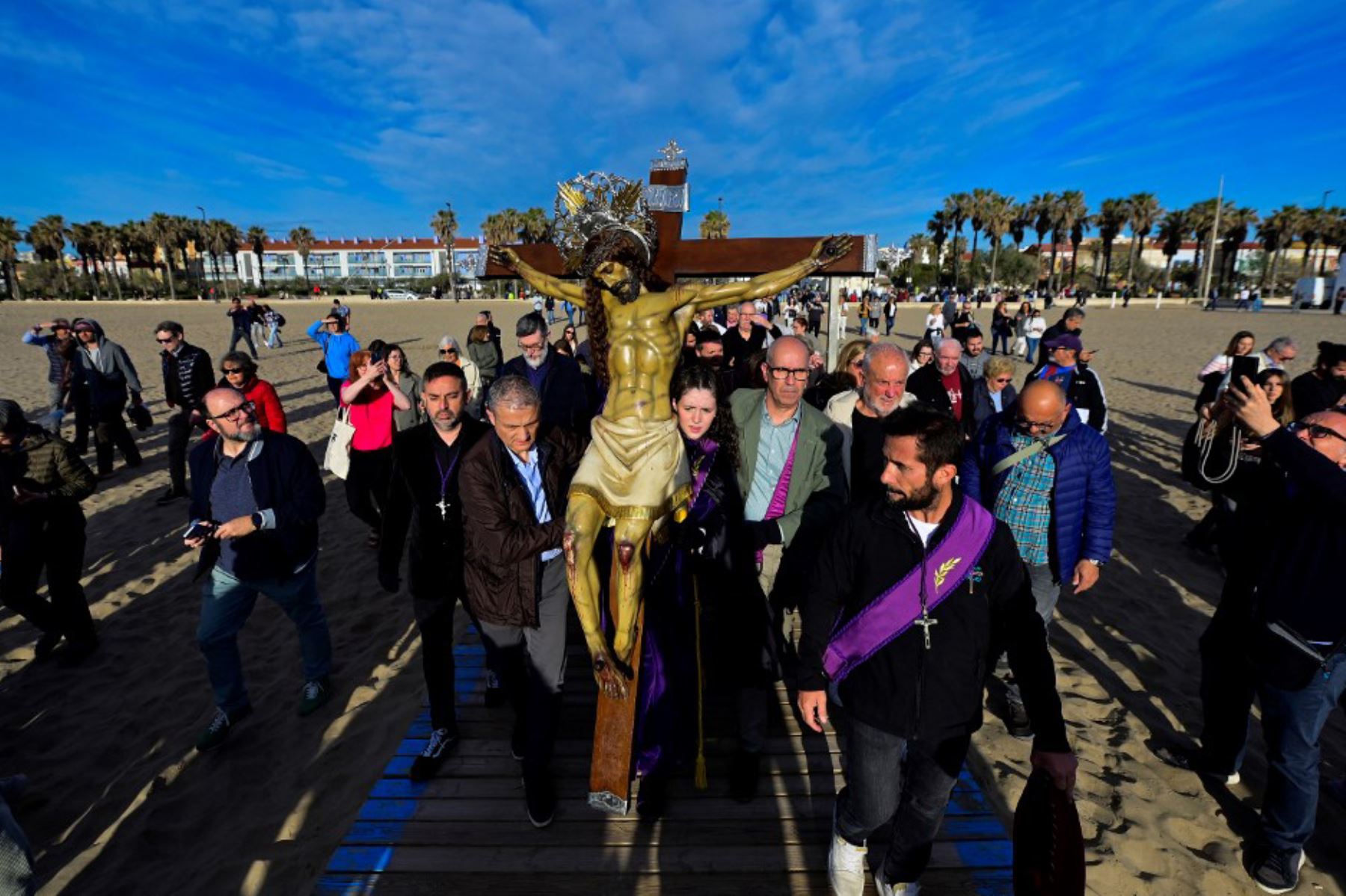 Penitentes llevan una efigie del "Cristo Salvador" en la playa de Valencia durante la Semana Santa el 18 de abril de 2025. Foto: AFP