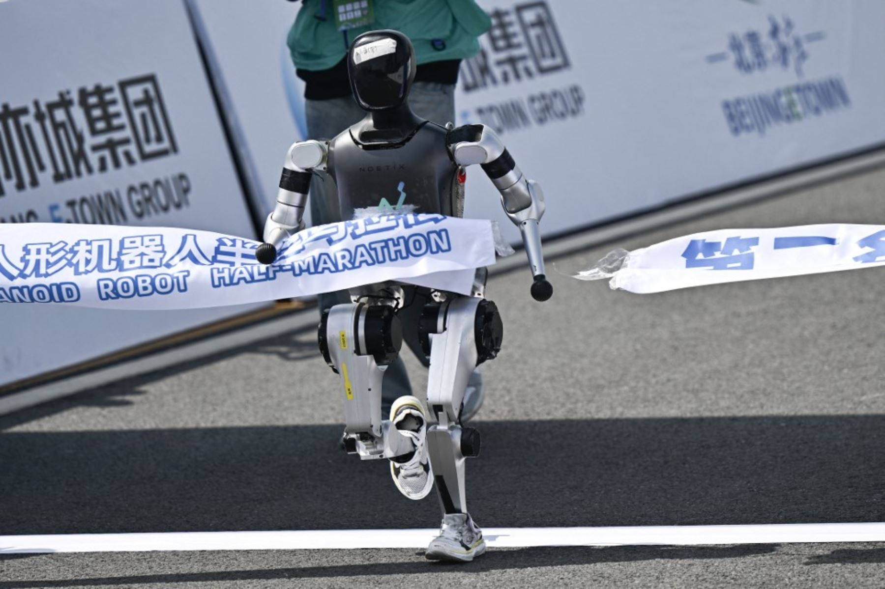 Un robot cruza la línea de meta en la media maratón de robots humanoides en Beijing el 19 de abril de 2025. Decenas de robots humanoides salieron a las calles de Beijing, uniéndose a miles de participantes humanos en una media maratón pionera en el mundo que muestra el impulso de China para liderar la carrera mundial en tecnología de vanguardia. Foto: AFP